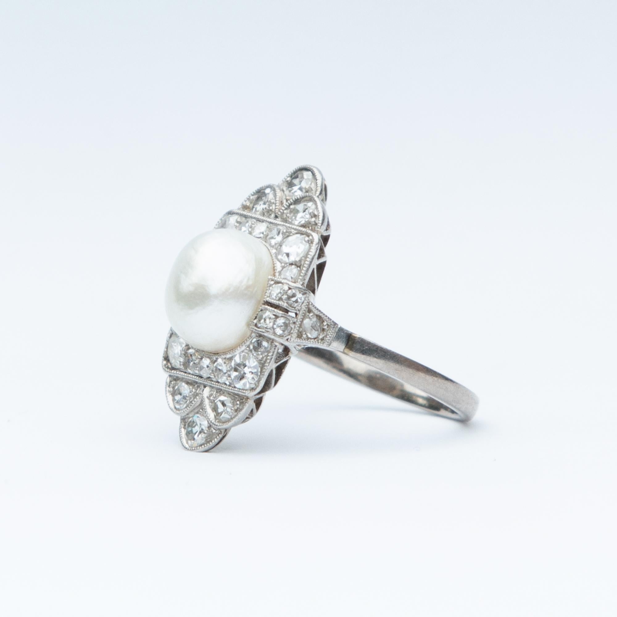 A stunning example of an Art Deco Panel Ring. Set in platinum with a central exquisite quality natural pearl surrounded by diamonds. Total diamond weight certified 0.98 carat, H colour and clarity SI-2.

Head: 21.4 x 14.03

Size: M 1/2 or 6.5 

