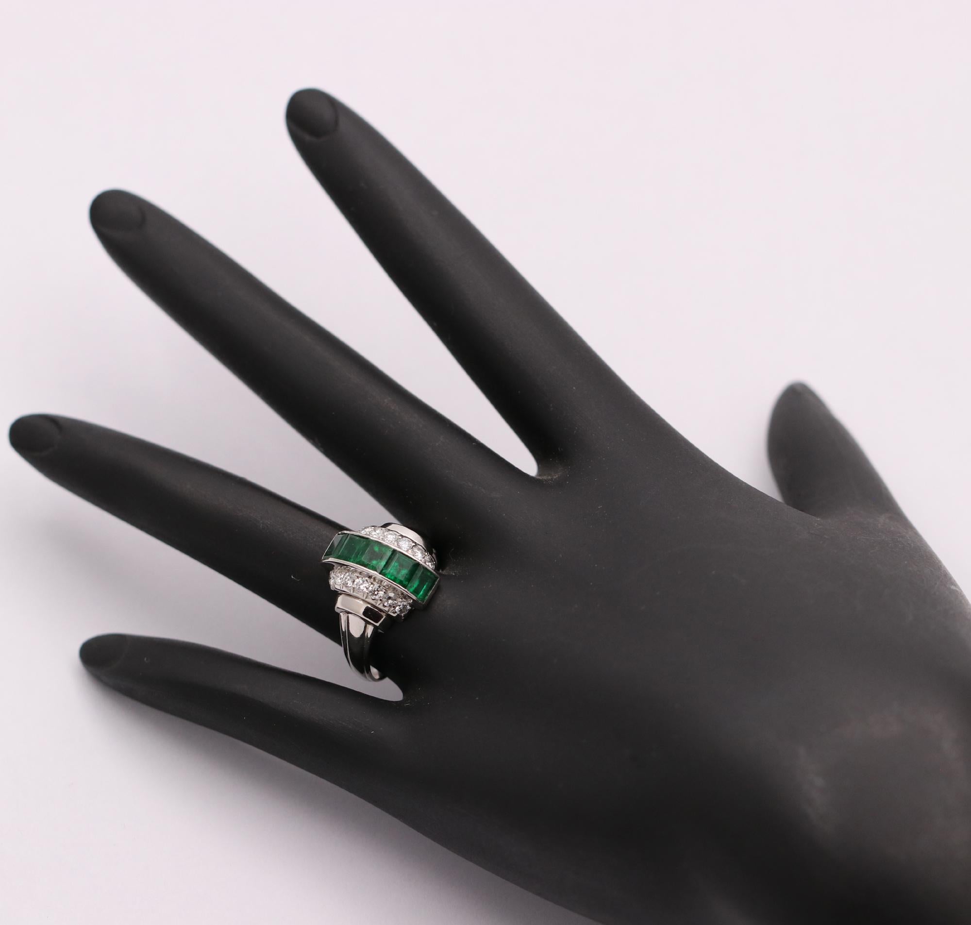 A beautiful platinum ring, centered around 5 square-cut emeralds weighing approximately 2.25ct total weight. With its tailored deign, it uses sleek lines on the shoulders as well as 14 diamonds, for sparkle, and definition. The shank of this dinner