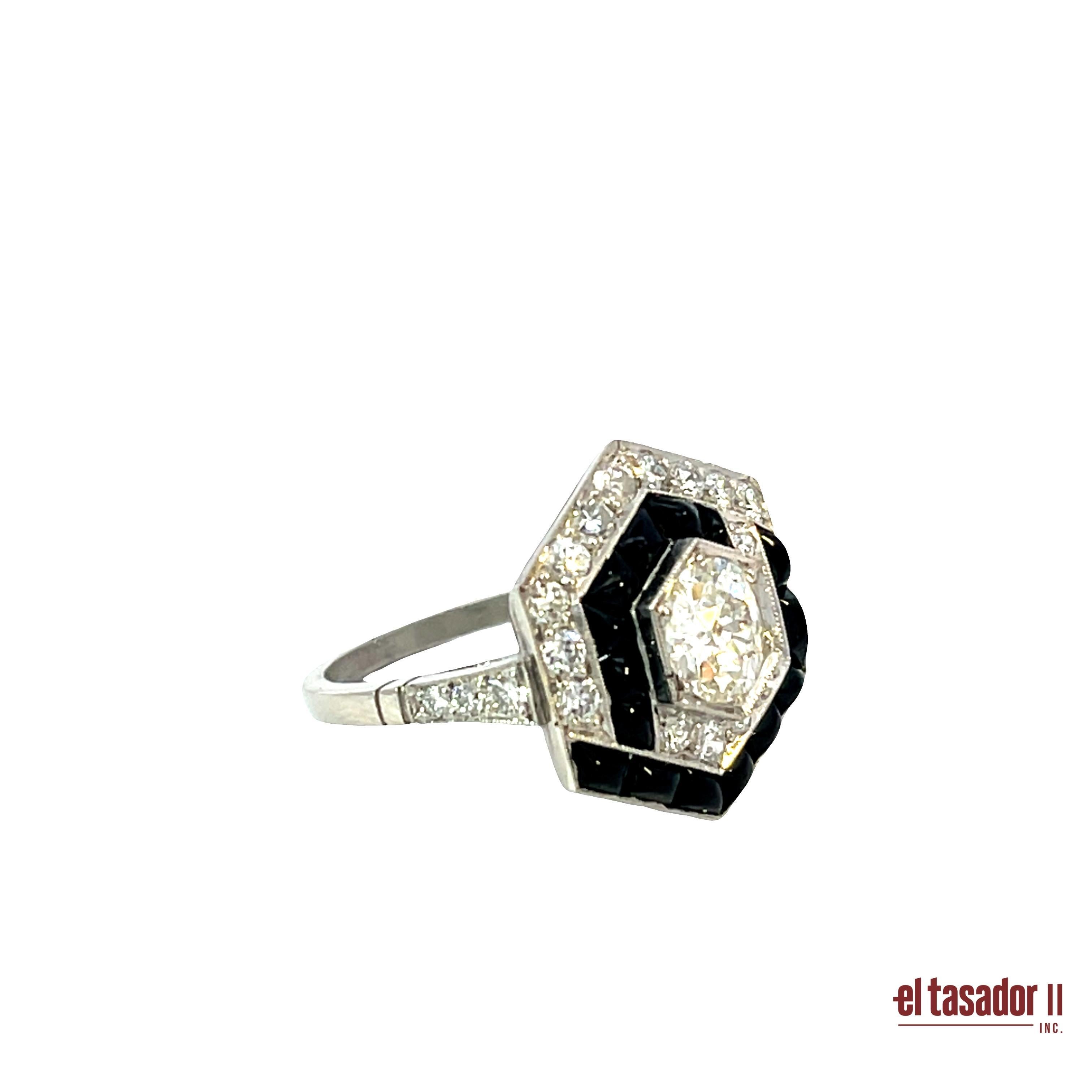 Cette étonnante bague en platine d'inspiration Art déco pèse 7 grammes et présente un audacieux motif géométrique hexagonal. En son cœur se trouve un diamant taille brillant de 0,91 carat, plein de feu et d'éclat. Entourant la pierre centrale, 0,64