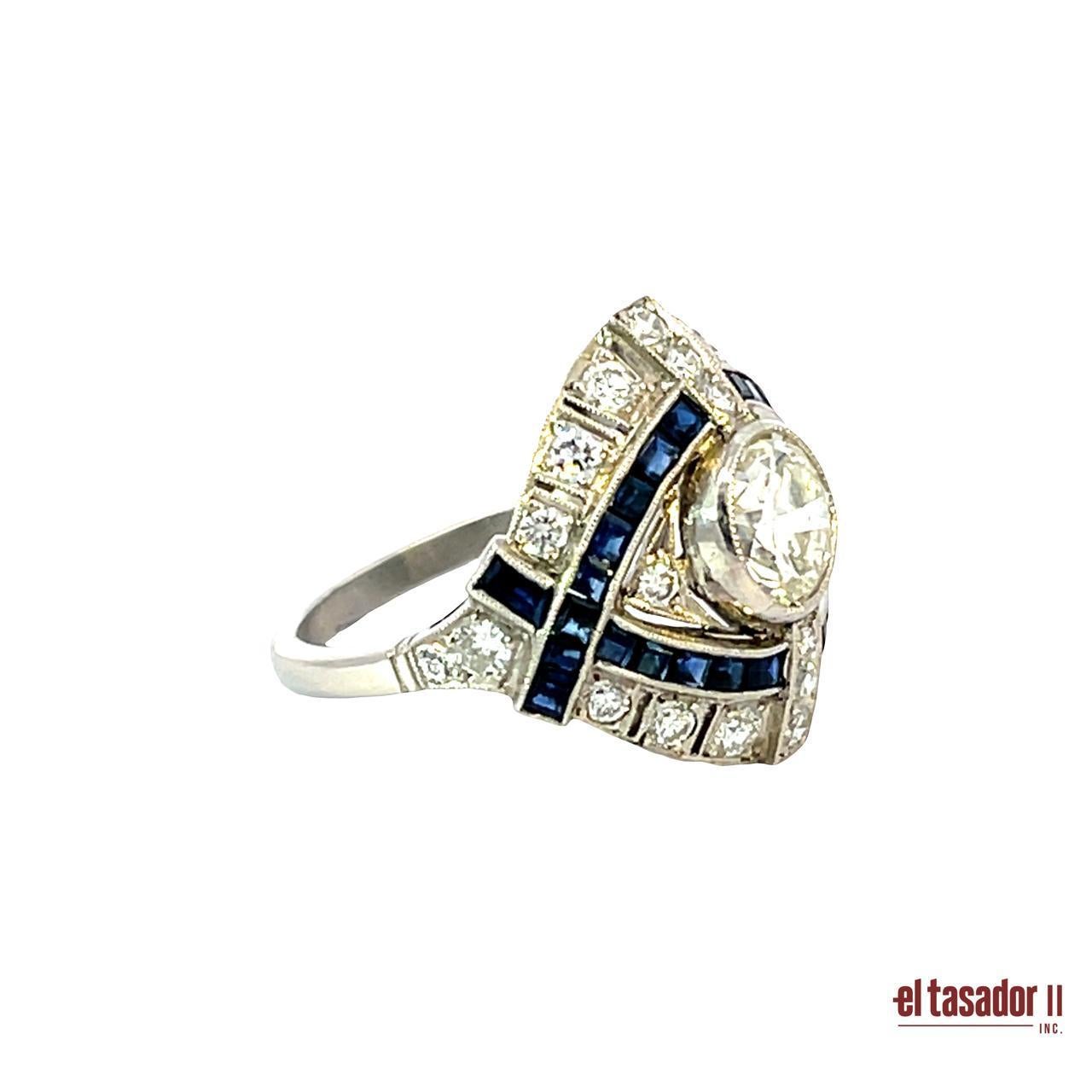 Crafted in platinum and weighing 7.3 grams, this bold Art Deco-style ring features a 1.35-carat brilliant-cut diamond at its center, surrounded by 0.85 carats of additional diamonds and 2.12 carats of carre-cut sapphires. The striking geometric
