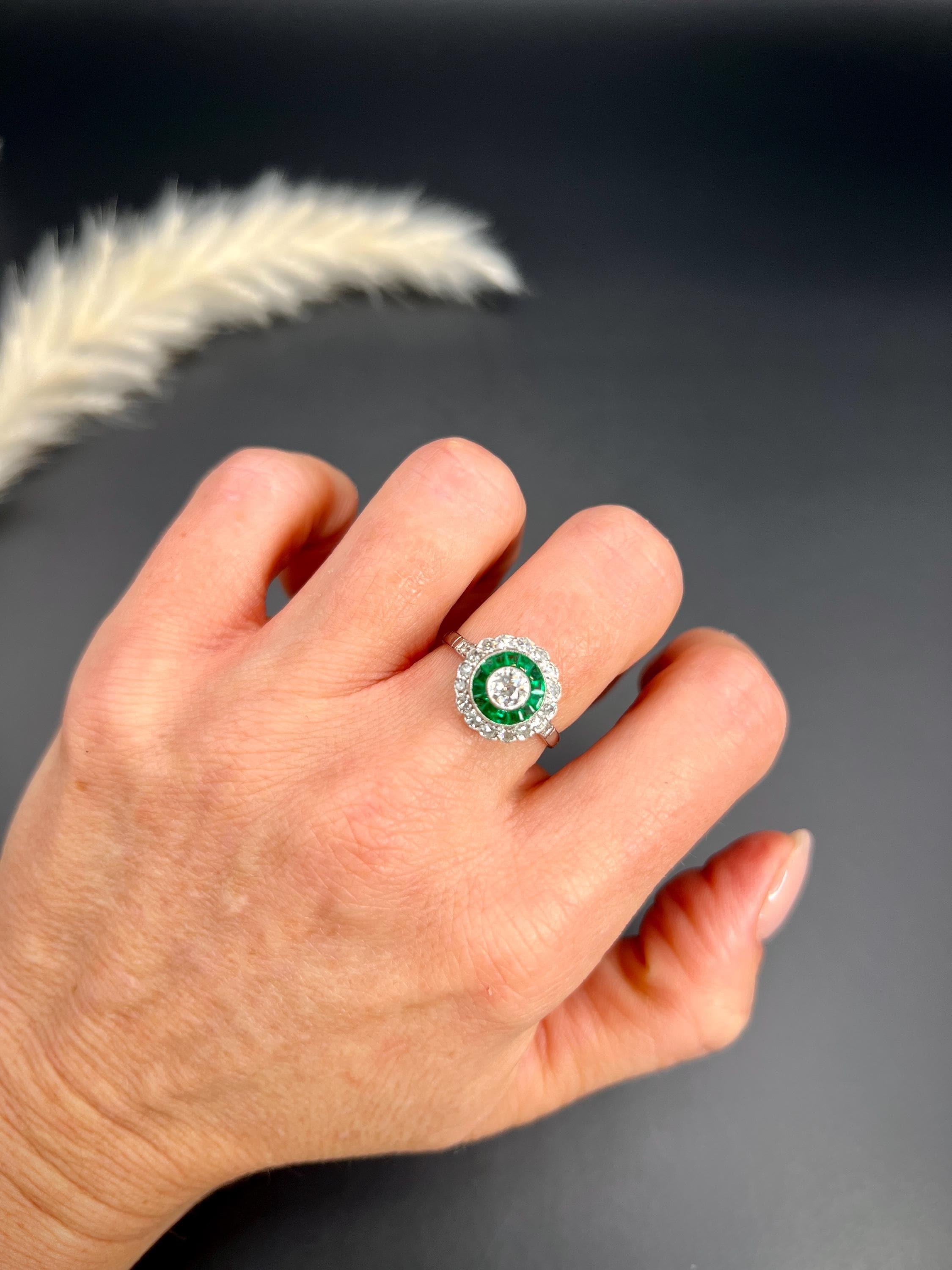 Anello target con smeraldo 

Testato al platino

Circa 2000

Questo splendido anello bersaglio è disegnato in stile deco e catturerà sicuramente l'attenzione di chiunque lo veda. Il centro è costituito da un diamante naturale circondato da smeraldi