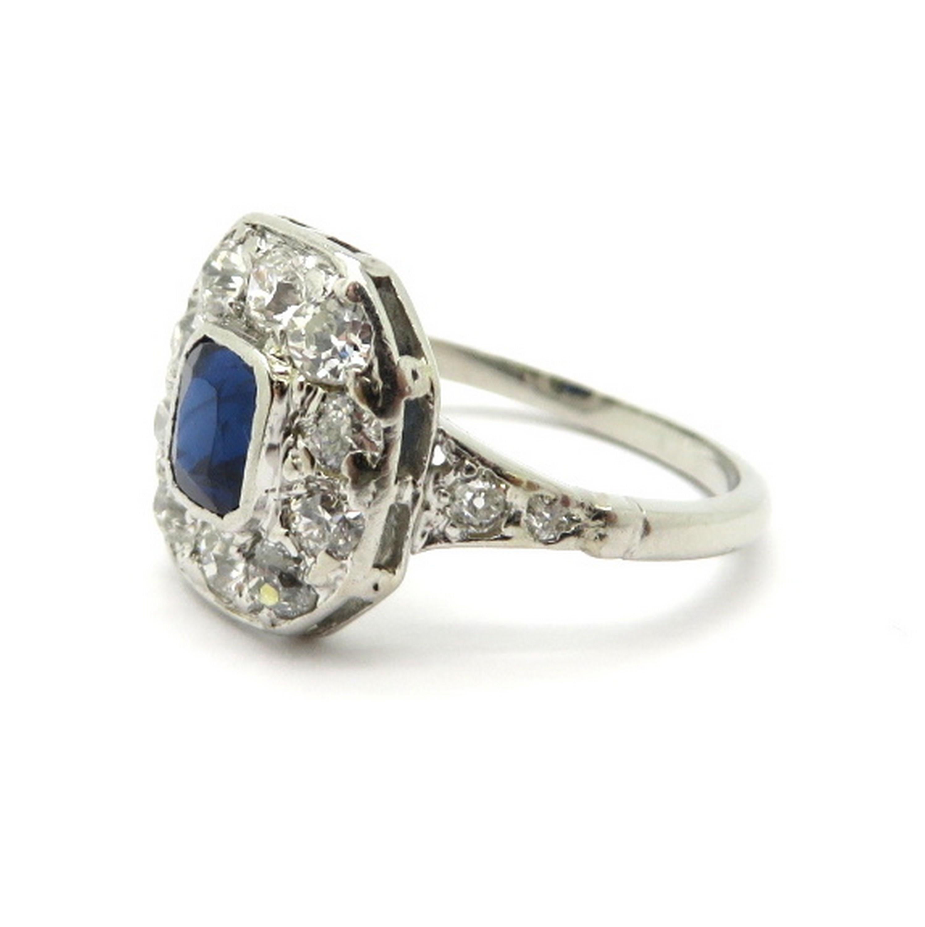 Platinum Art Deco style sapphire and diamond ring. Showcasing one fine quality natural bezel set cushion shaped sapphire weighing approximately 0.70 carats. Accented with 14 micro prong set Old European cut diamonds, weighing a combined total of