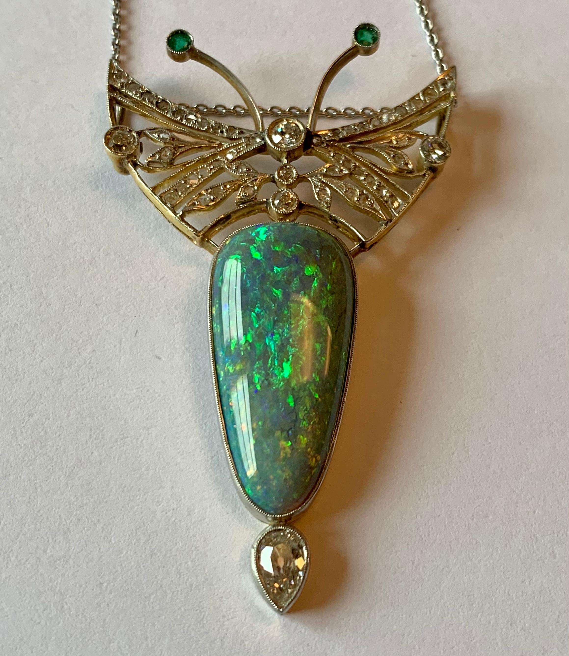 Breathtaking Opal Diamond and Emerald  Butterfly pendant with chain in Platinum and yellow Gold. Set with an Opal 2.5 cm x 1.3 cm with a nice play of color, 1 park shaped Diamonds ca. 0.40 ct, 48 brilliant cut Diamonds ca. 0.70 ct and 2 tiny emerald