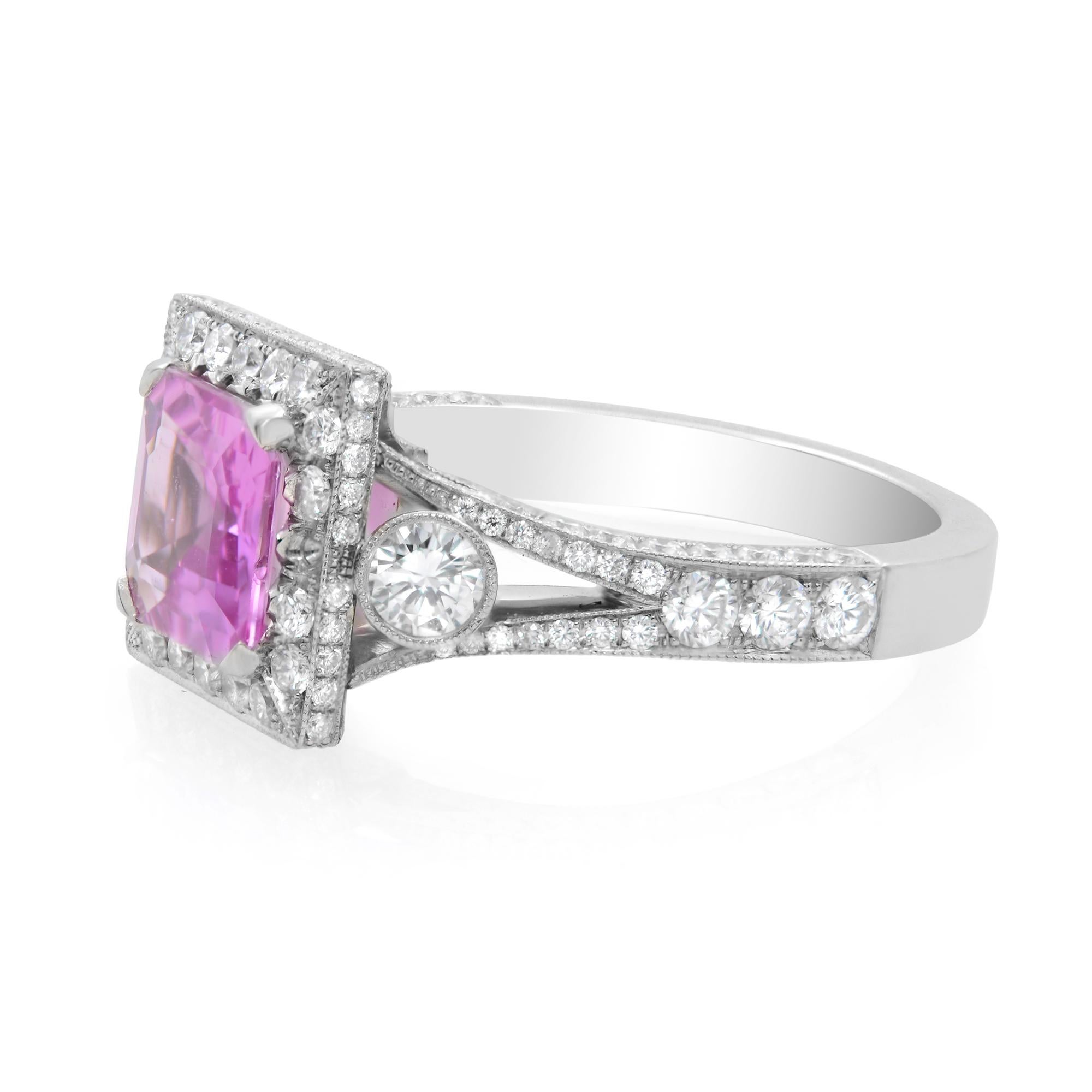 An Asscher cut pink Sapphire 1.53cts is held in a prong setting, surrounded by a dazzling diamond halo. The delightful pink hue beautifully blends with the brilliance of the diamonds. This platinum pink sapphire halo engagement ring is also adorned