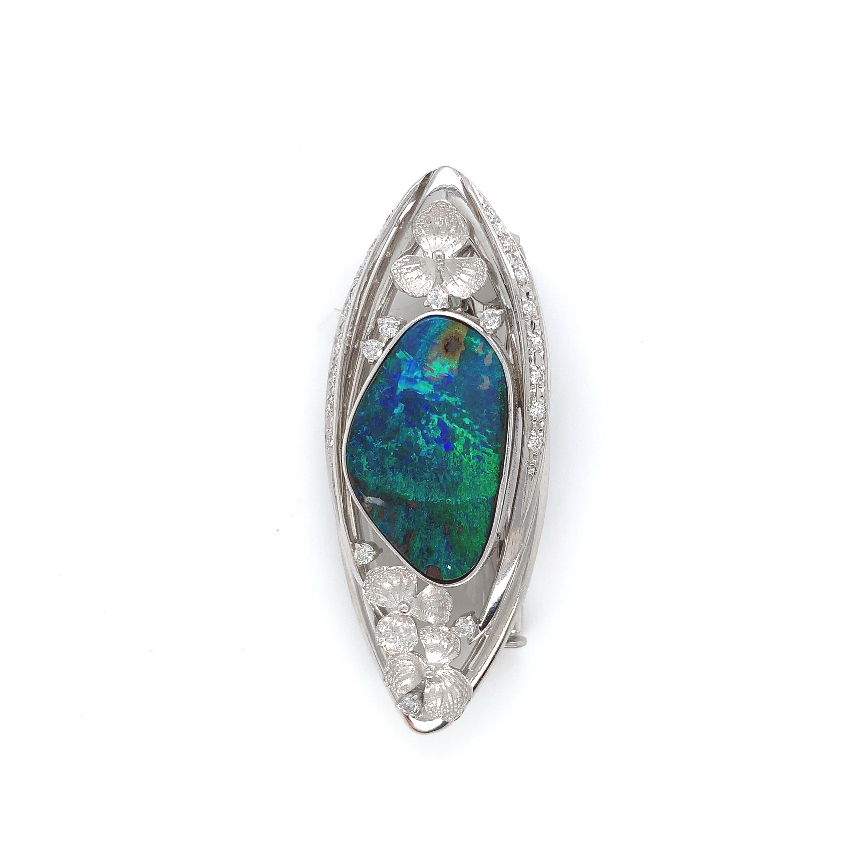 Incredible platinum pin/pendant featuring a large Australian black boulder opal. The opal has blue-green play of color with brown ironstone. The large opal measures about 22mm x 14mm with an oval freeform shape. The opal is set in a heavy custom