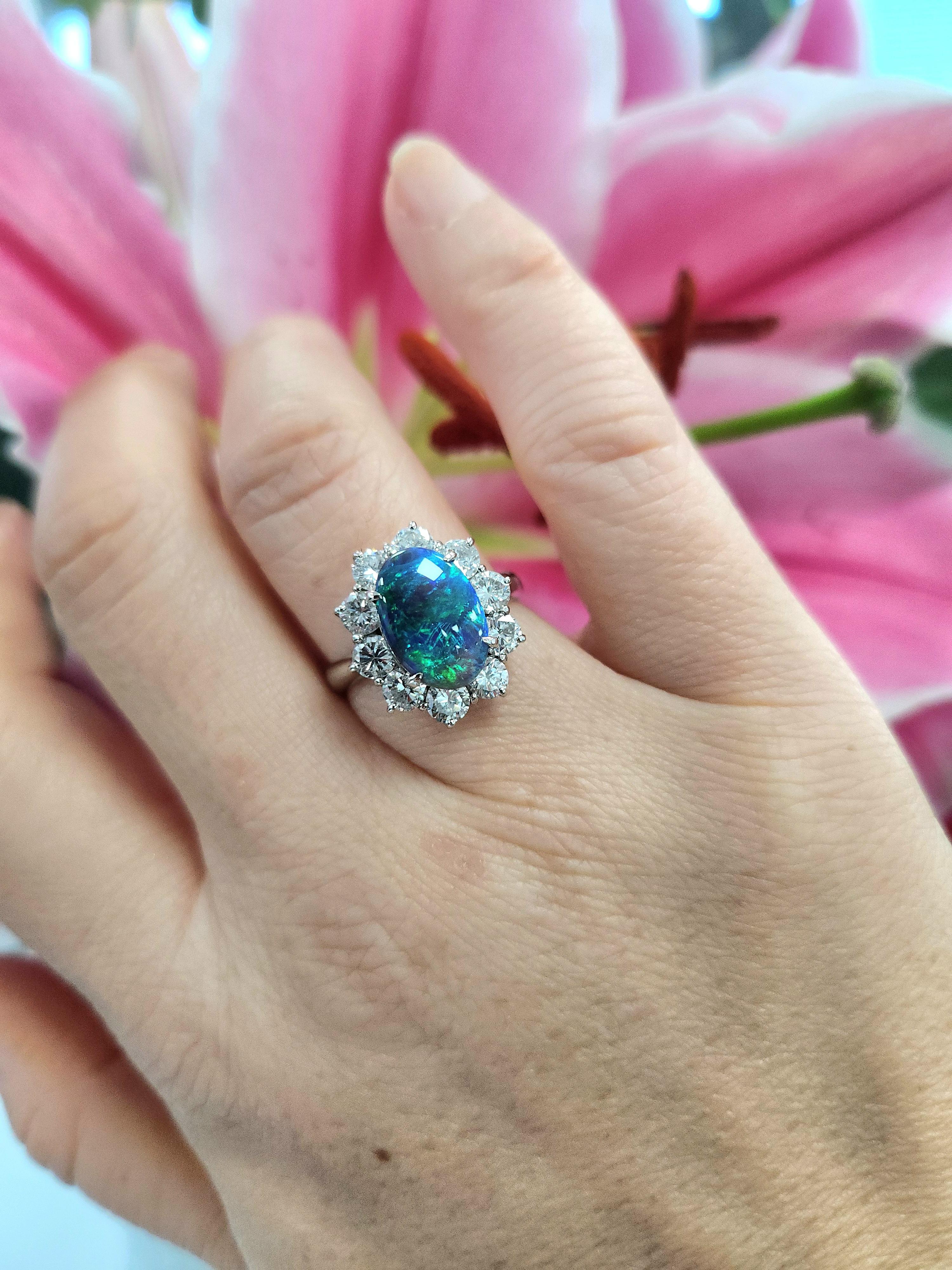 Experience the breathtaking beauty of nature’s palette with this exquisite opal and diamond ring, a luxurious statement piece crafted in rich, enduring platinum. The centerpiece of this ring is a mesmerizing natural opal, weighing 1.70 carats, that