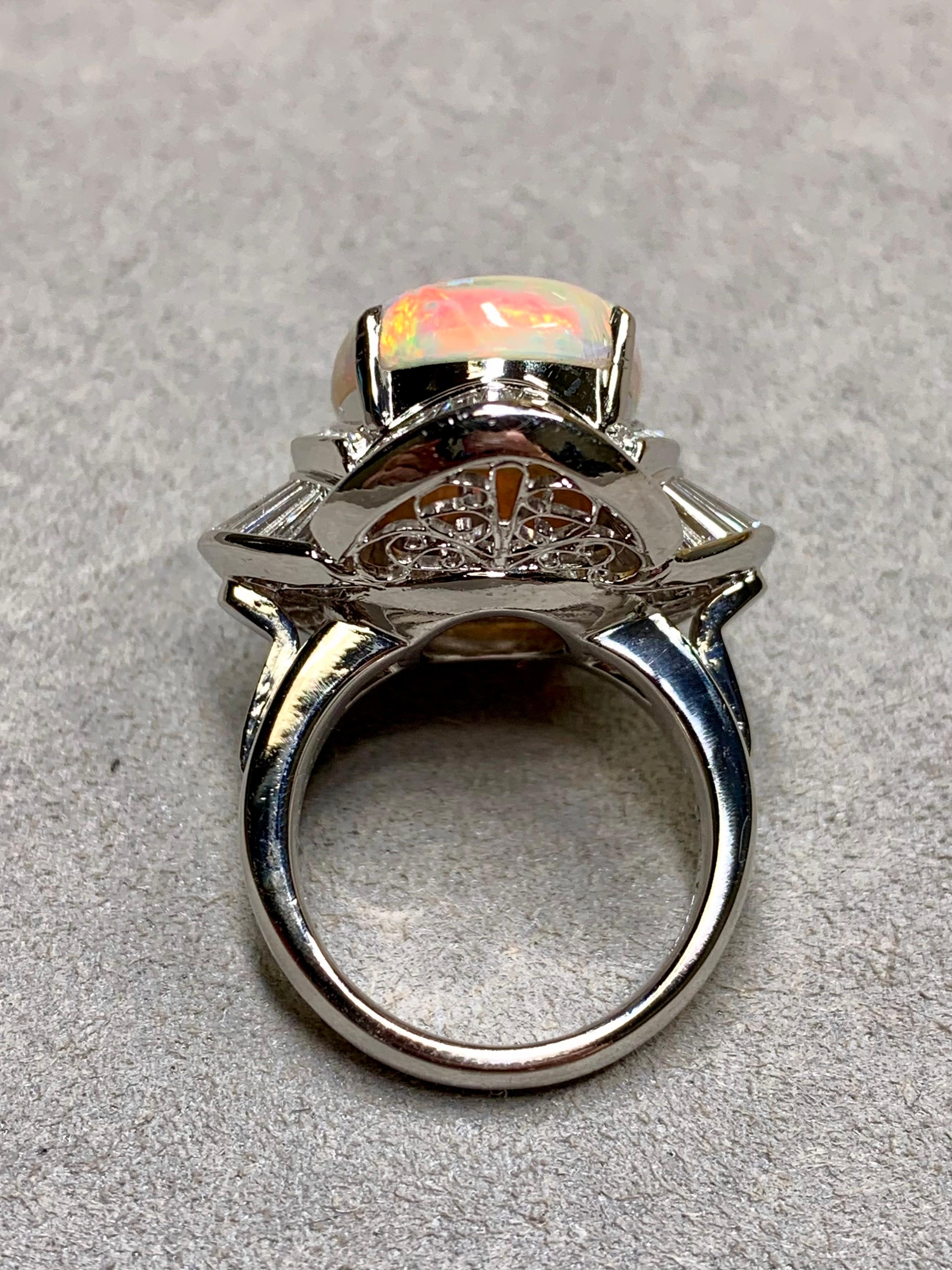 
A fabulous ballerina ring done in heavy platinum and centered by a 7.66ct (known weight) natural Australian opal exhibiting primarily the most desirable reds and oranges with scattered blues and greens. The center is surrounded by perfectly