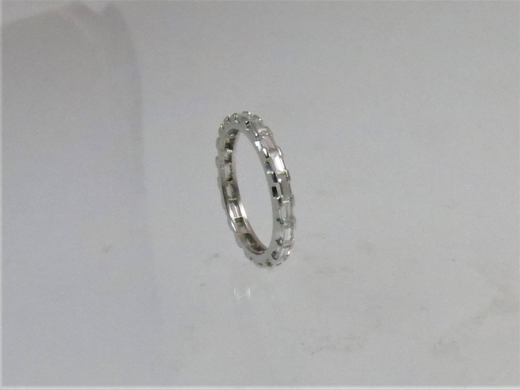 Platinum wedding band, bar set all around with 20 straight baguette diamonds weighing approximately 1.00cts, GH color, VS clarity,
Finger size 6