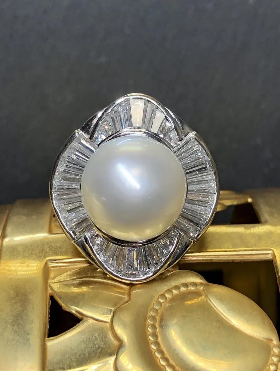 A fabulous cocktail ring newly made in platinum and set with approximately 3.10cttw
in tapered baguette and round diamonds all being G-I in color and Vs1-Si1 in clarity. This ring also boasts a 12.70mm natural South Sea pearl with a beautiful and