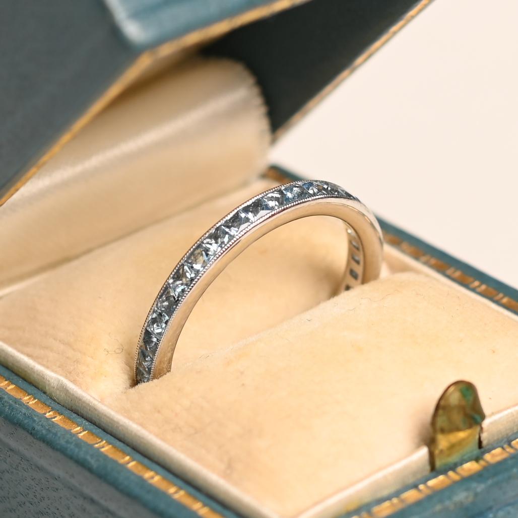 Questa squisita fascia per l'eternità mette in mostra una fila ininterrotta di acquamarine a taglio francese, meticolosamente incastonate nel platino. Il blu tenue e sereno delle acquemarine è splendidamente completato dalla fresca lucentezza del