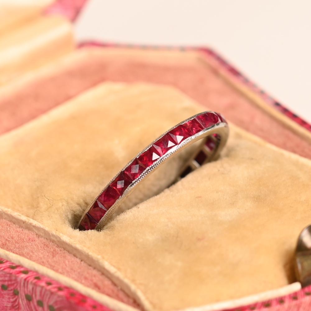 Dieses exquisite Platinband für die Ewigkeit ist elegant mit einer Reihe von Rubinen im französischen Schliff (ca. 1,30 Karat) eingefasst. Das Band hat eine Breite von 2,40 mm und ist mit einer zarten Maserung verziert, die seinen Vintage-Charme