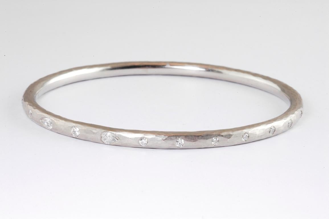 4mm hammered platinum bangle with pear shaped diamonds 0.30cts total and round brilliant cut diamonds 1.30cts total handmade in Notting Hill, London by renowned British jewellery designer Malcolm Betts.
 The  matt finish on the Platinum compliments