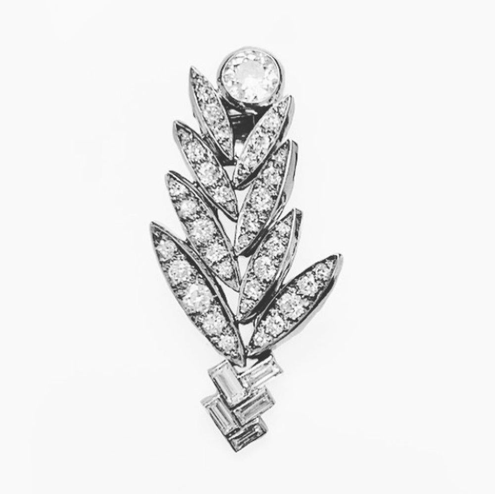Elevate your style with the exquisite Suzanne Belperron Platinum Diamond Palm Brooch, a testament to the designer's unparalleled craftsmanship. This exceptional piece features a large brilliant round-cut diamond, surrounded by a harmonious