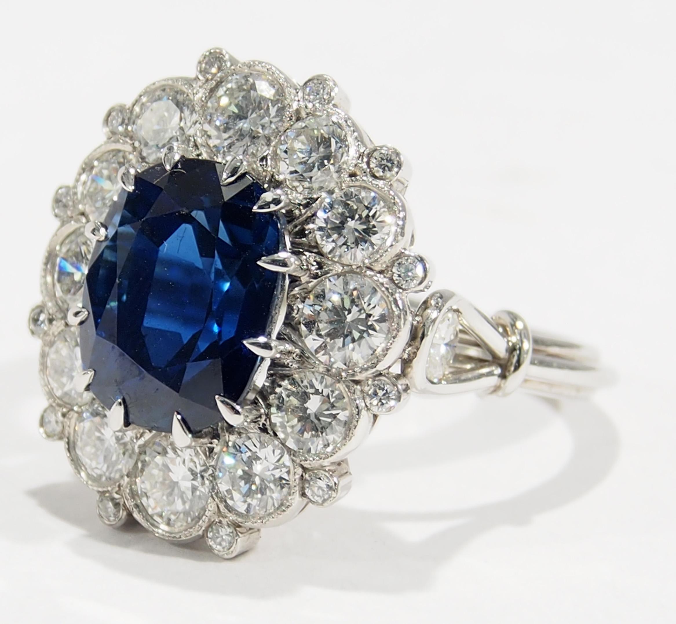 This is a stunning Platinum Diamond and Siam Sapphire Handmade Ring. A heirloom quality Ring with (26) Round Brilliant Cut Diamonds, approximately 9.45ctw, D-F in Color, VVS-VS in Clarity that enhance a Siam Sapphire, approximately 7.05ct. This