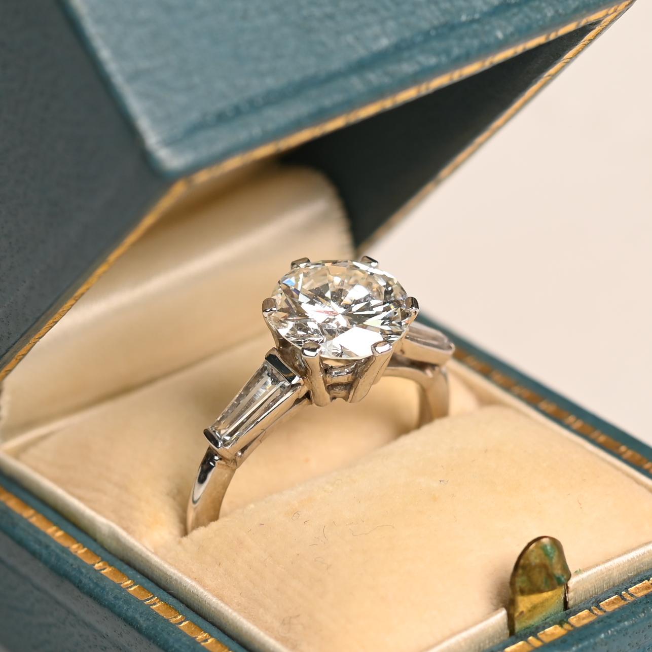 Questo squisito anello con diamante vintage presenta una splendida pietra centrale rotonda con taglio a brillante, del peso di circa 2,50 carati. Certificato da GIA, il diamante vanta un colore di grado I e una purezza VS2, offrendo una brillantezza