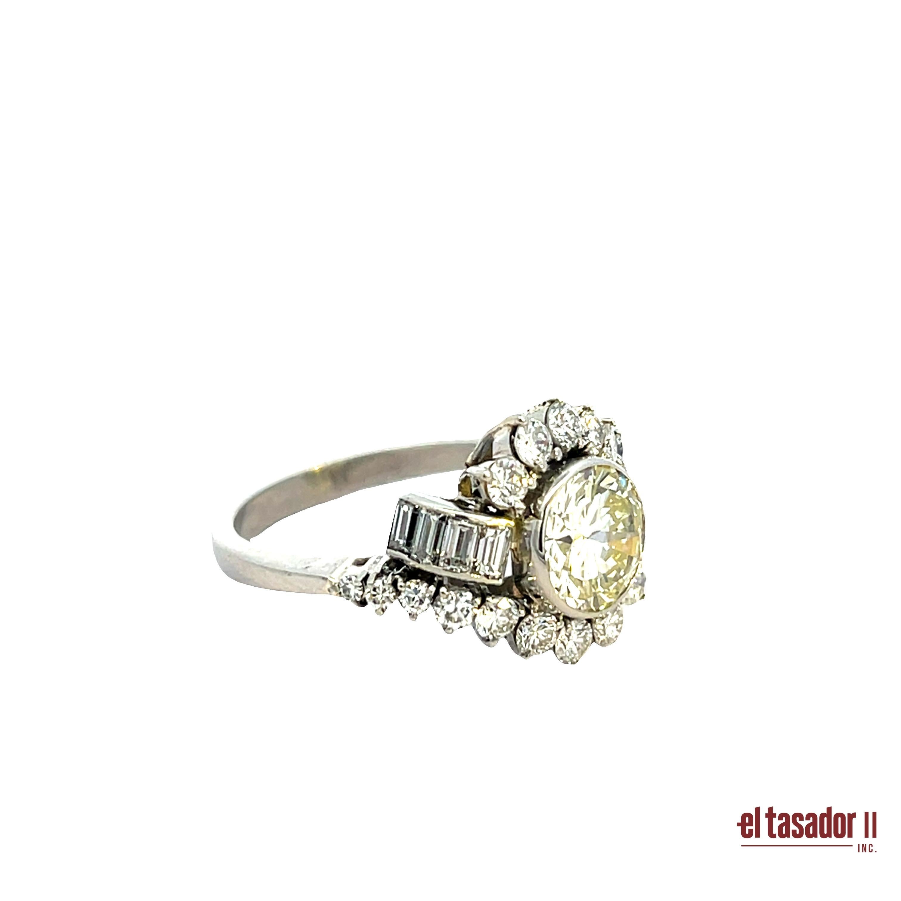 This platinum bypass ring showcases a striking 1.75-carat brilliant-cut diamond at its center, set in a smooth bezel that enhances its natural fire. The asymmetric design is adorned with tapered baguette-cut diamonds and brilliant-cut accents,