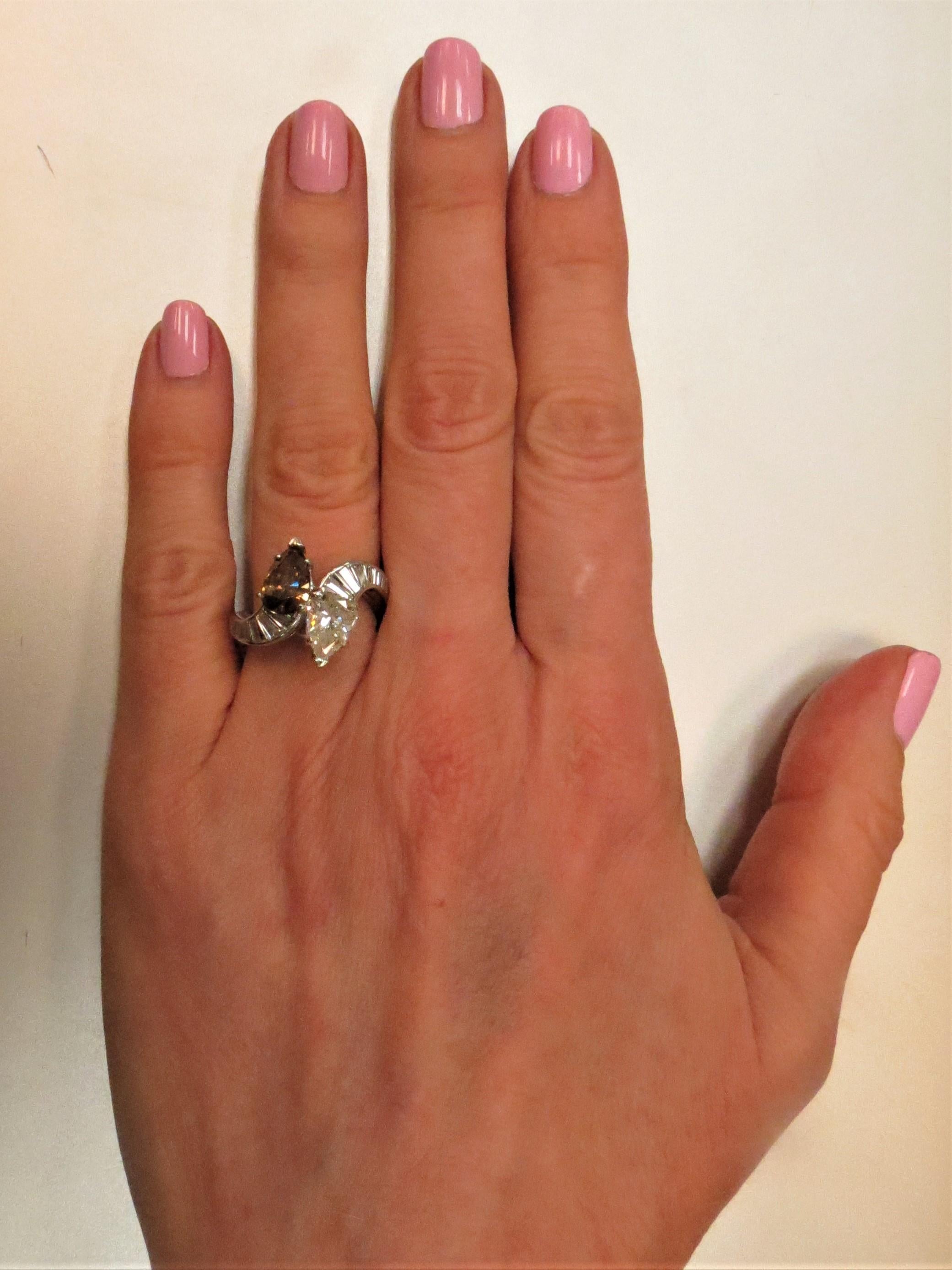 Bague bypass en platine sertie de  1.un diamant poire de 31 ct, couleur H, pureté I1 et un diamant cognac poire de 1,36 ct, pureté SI2 et 14 diamants baguette pesant environ 1,00 ct, couleur G-H, pureté VS
Taille 6, peut être ajustée
Dernier prix de