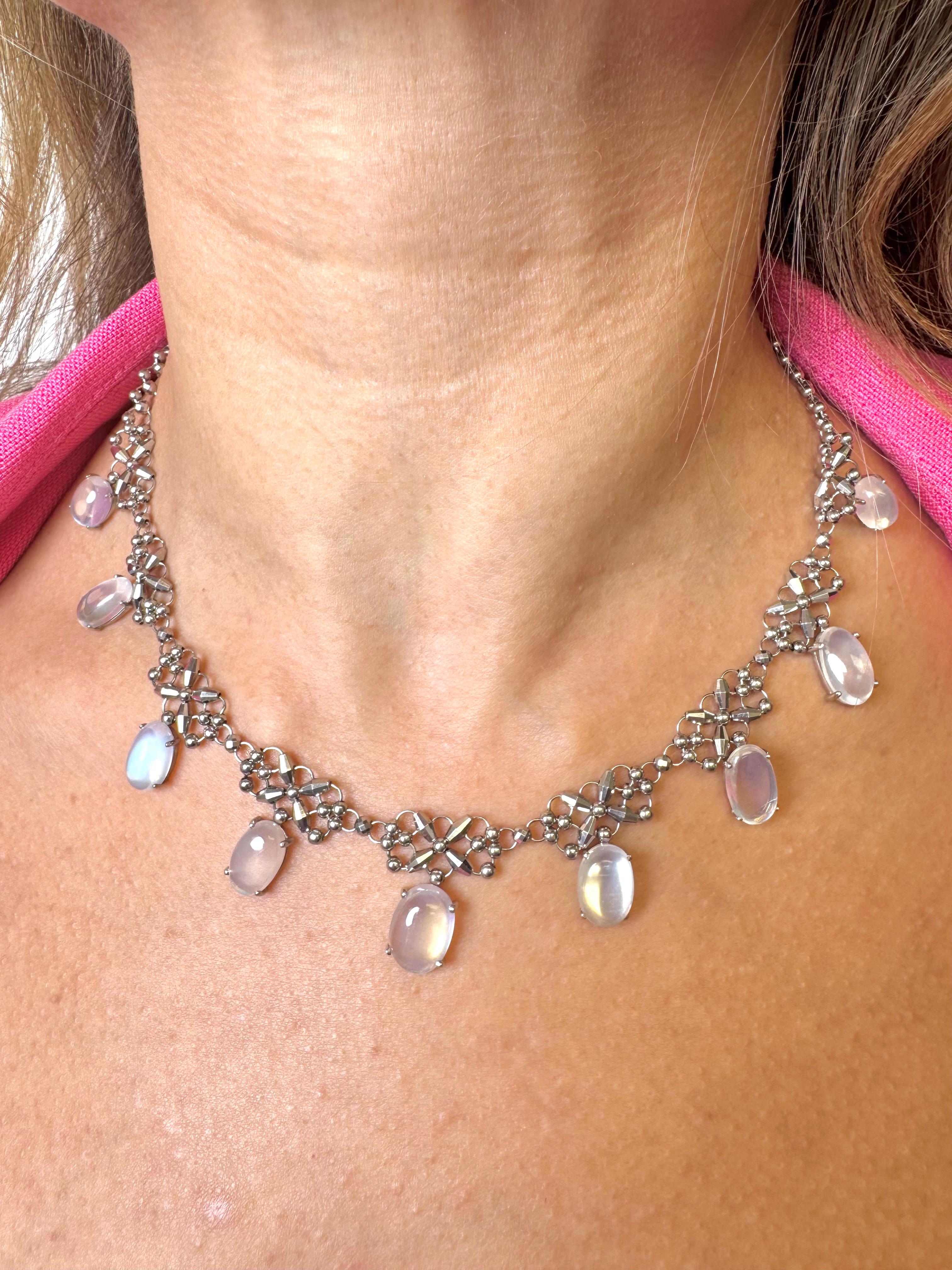 Una collana elegante e raffinata, realizzata in platino e timbrata Pt 850, con un delicato reticolo di perline in platino lucido e motivi geometrici. Ornato da nove pietre di luna ovali cabochon, questo design a frangia danza meravigliosamente lungo