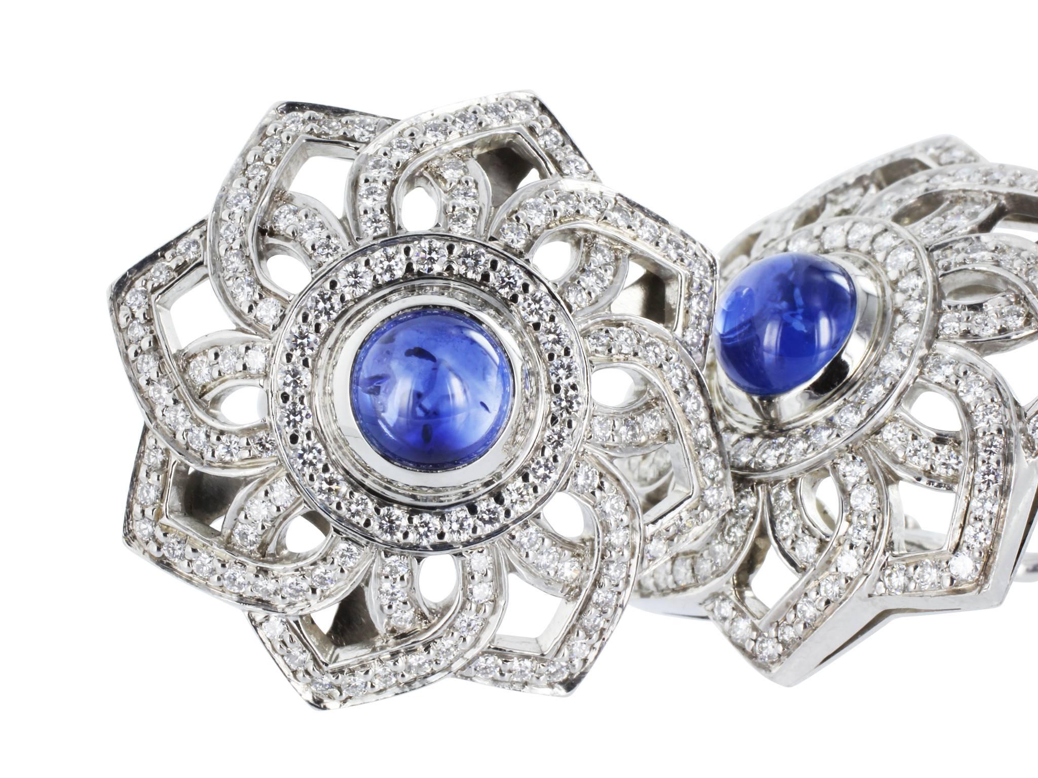 Platinum geometric pinwheel designed clip earrings, consisting of two cabochon cut sapphires having a total weight of 3.42 carats and accented by 254 round brilliant cut diamonds having a total weight of 1.45 carats.