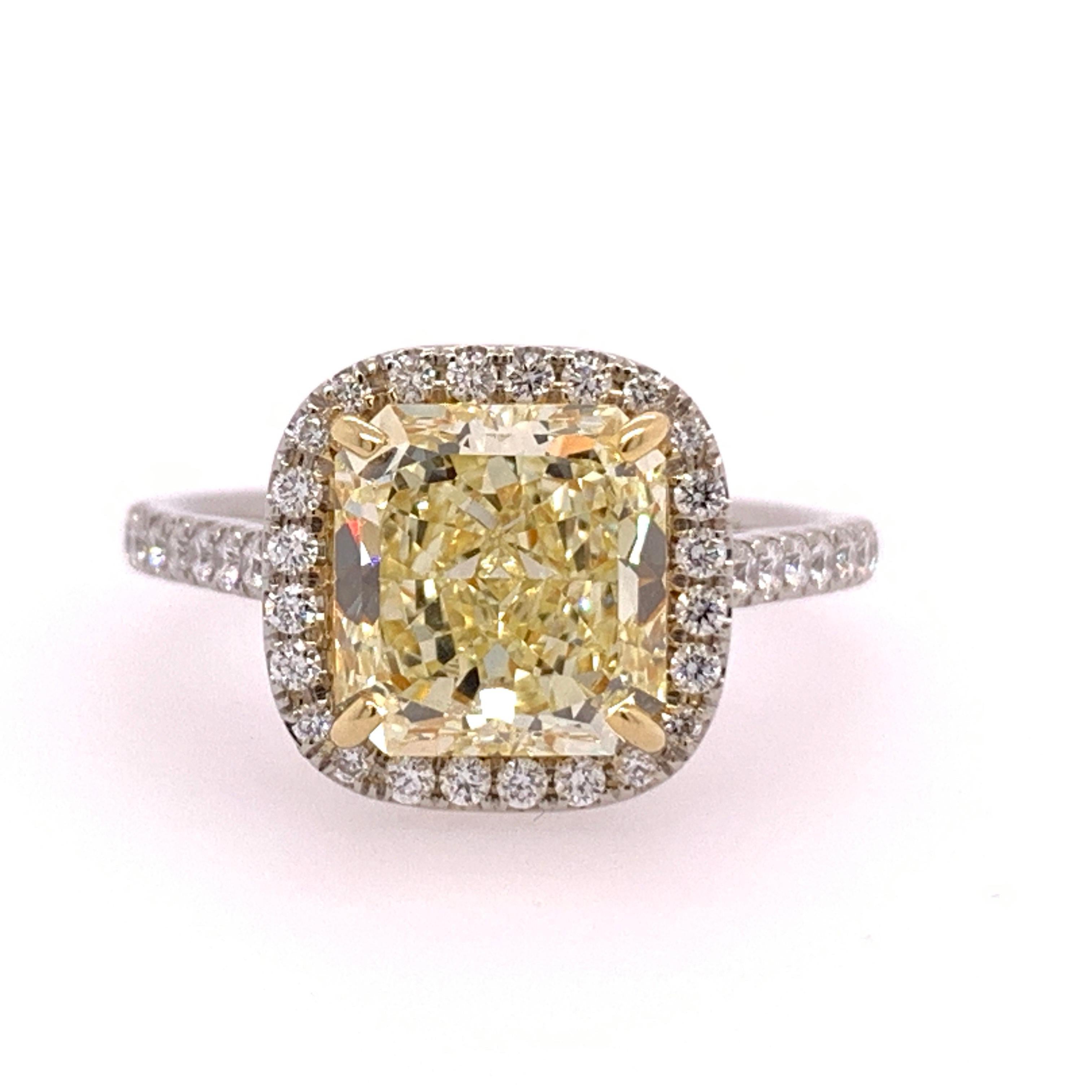 Platinum ring set with 46 Natural colorless round brilliant diamonds weighing a total of 0.40 carats. The ring size is a 6.

The centerstone is an exquisite Radiant Cut Natural Fancy Yellow, VVS1 clarity and No Fluorescence.
