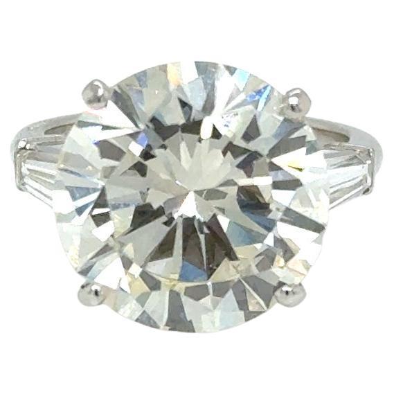 Dieser außergewöhnliche Ring von Cartier ist aus luxuriösem Platin gefertigt und präsentiert einen prächtigen Diamanten mit rundem Brillantschliff von 7,93 Karat, der von GIA mit der Farbe N und der Reinheit VVS2 bewertet wurde.
Flankiert von zwei
