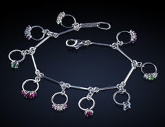 Bracelet de breloques en platine avec anneaux miniatures, diamants et pierres de couleur