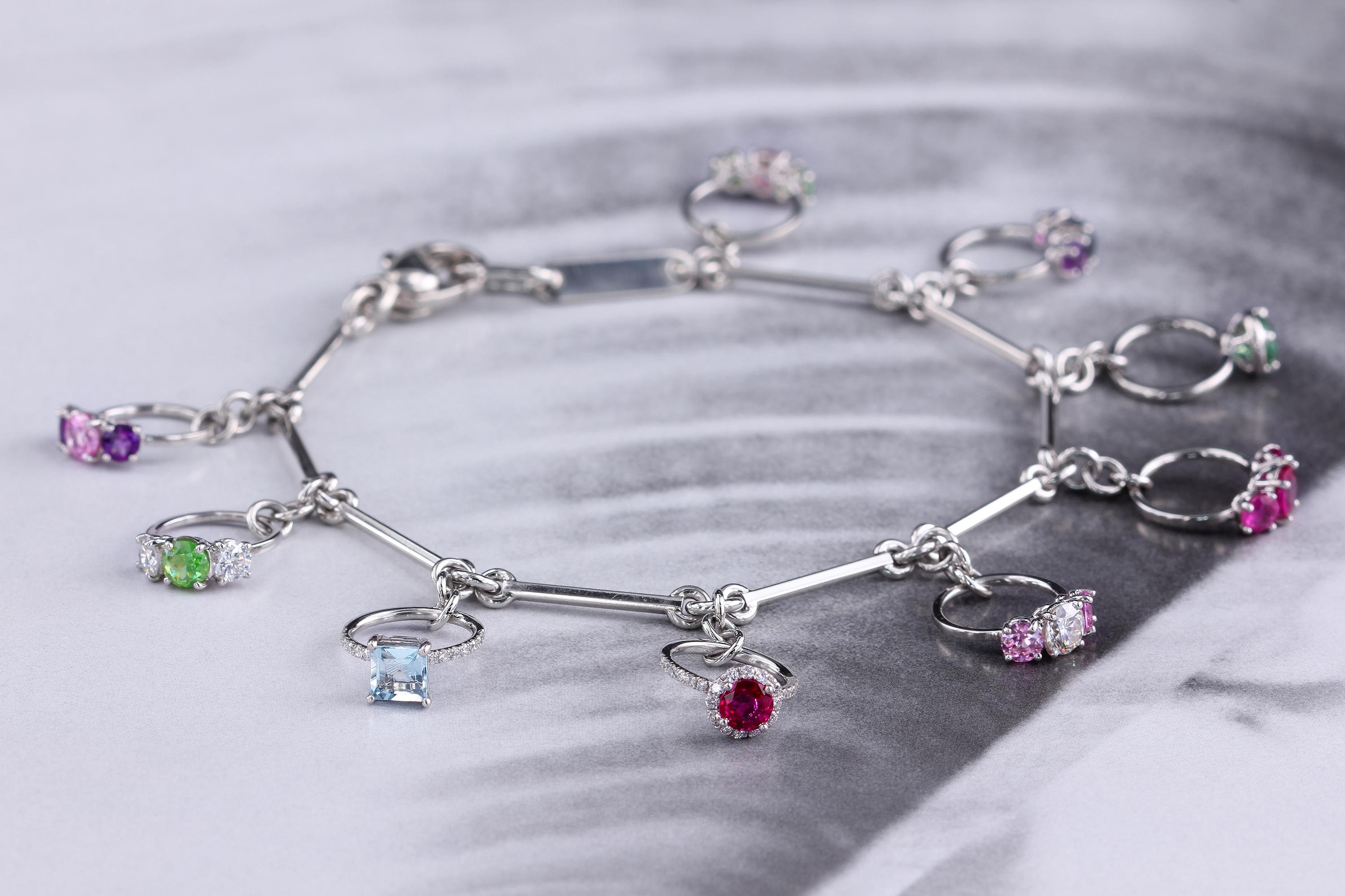 Artist Platinum Charm Bracelet with Miniature Rings Diamonds and Colored Gemstones For Sale