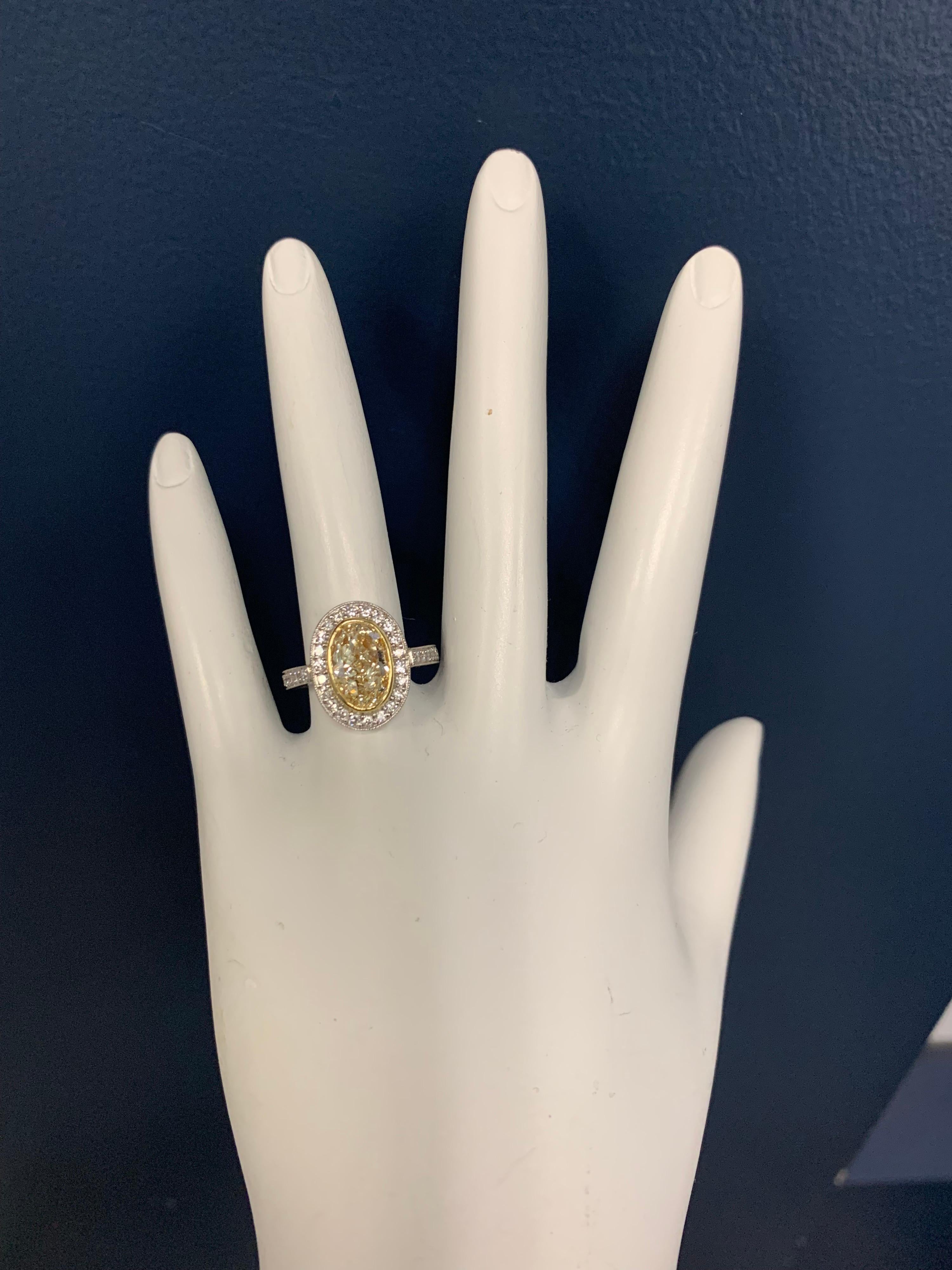 An elongated 2 carat Oval certified by EGL USA as a Light Yellow U-V and a vs2 clarity.  The ring includes 34 Natural Round Brilliant Colorless Diamonds weighing 0.32 carats. 

Total weight 2.32 carat, Ring is a size 6.5. 

