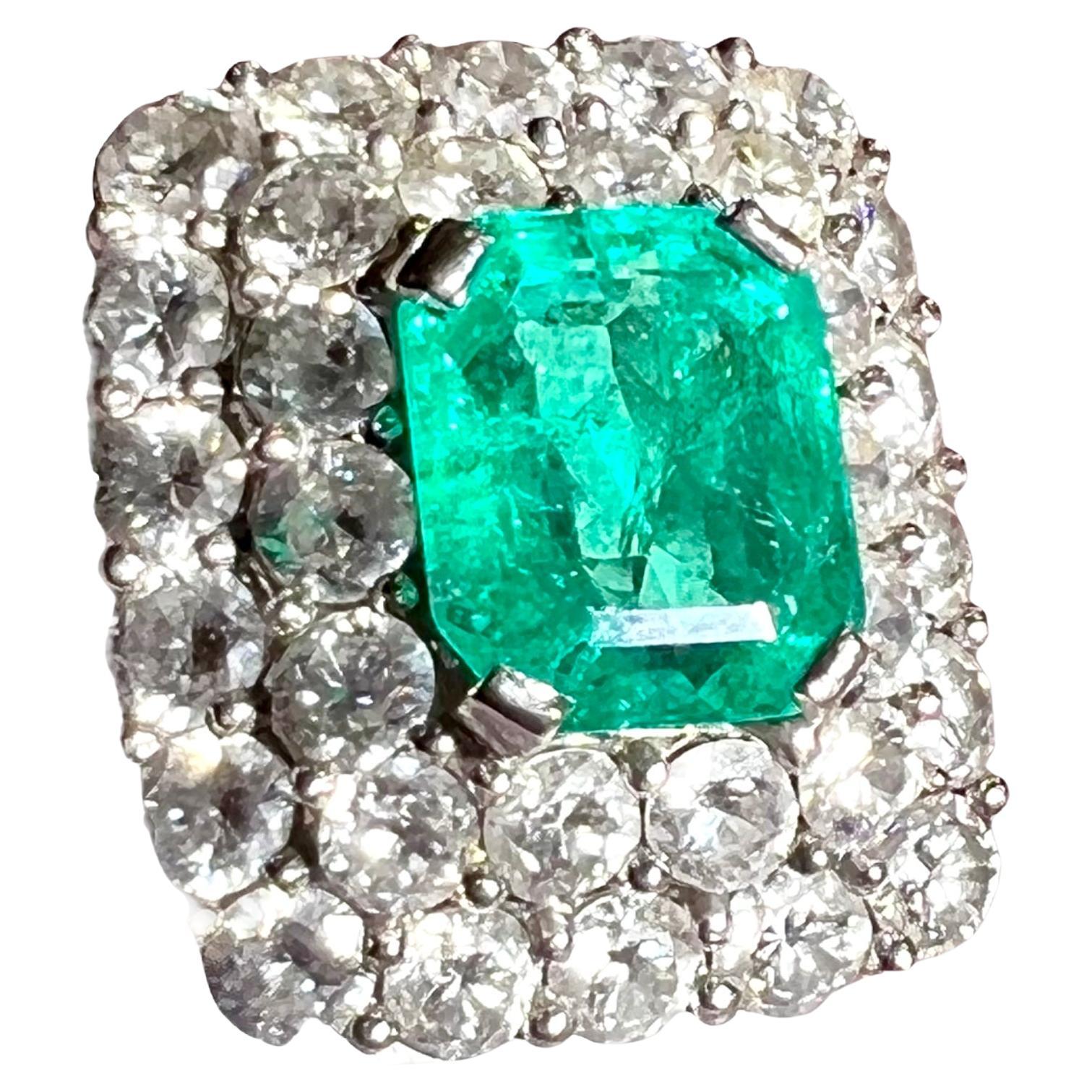 Wichtiger Platin Art Déco 1930/ 1940 Cocktailring, 
in der Mitte mit einem zertifizierten Smaragd von 3,38 Karat aus Kolumbien besetzt,  umgeben von 32 Diamanten im 