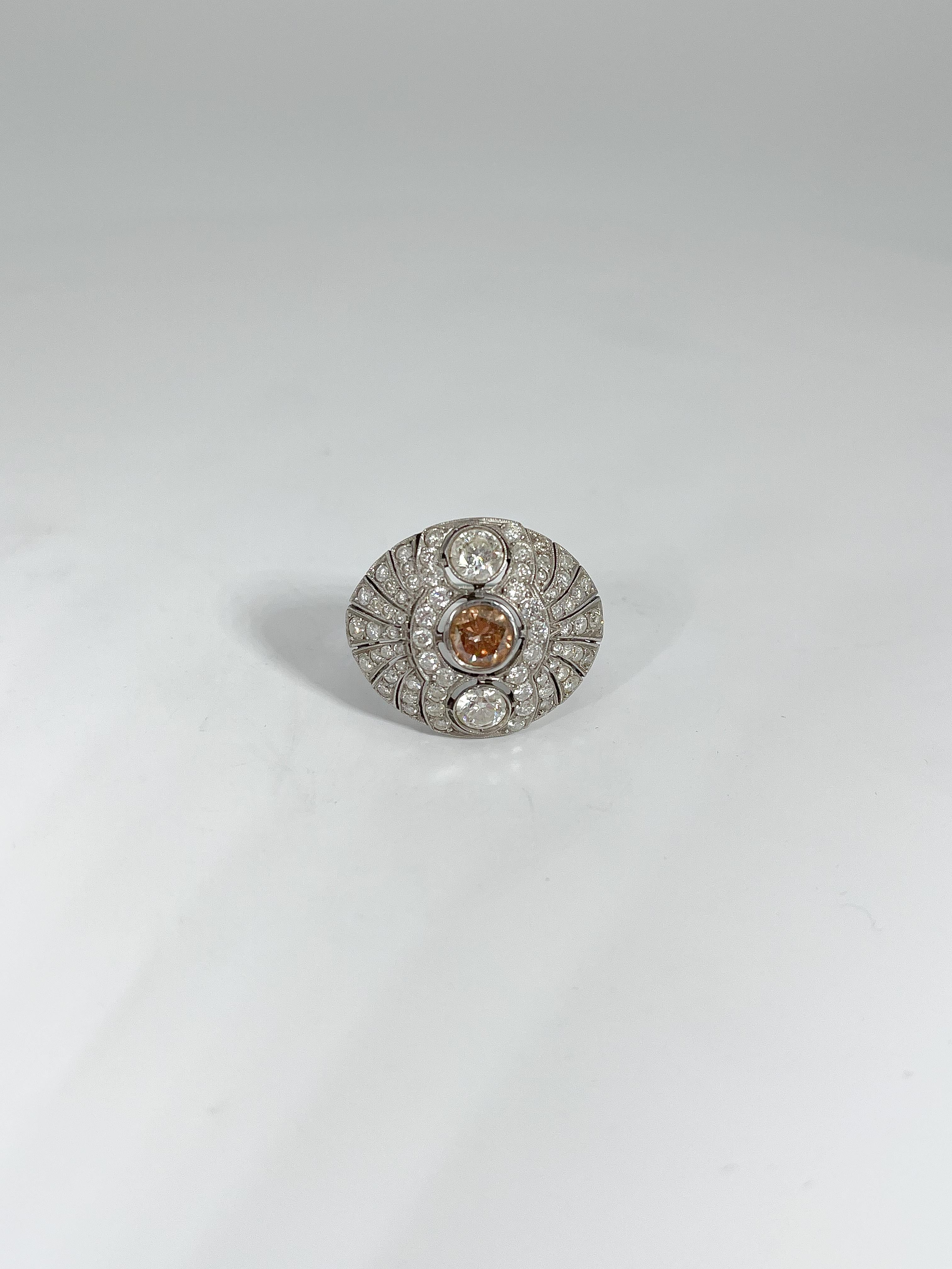 This unique platinum cocktail ring has 77 total diamonds including a beautiful cognac color diamond in the center. All stones are round cut. Ring measures size 7 1/4 and has a weight of 5.26.