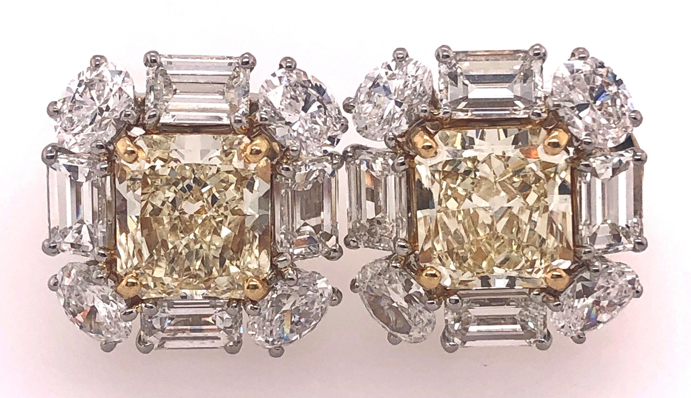 An  Importunate Platinum Fancy Yellow Diamond and Diamond Ear Studs. Each stone approx 3.18 &3.14 carats respectively. The two flanked by a group of approx four .50 baquette diamonds and four .30 oval diamonds of fine quality. The pair having a