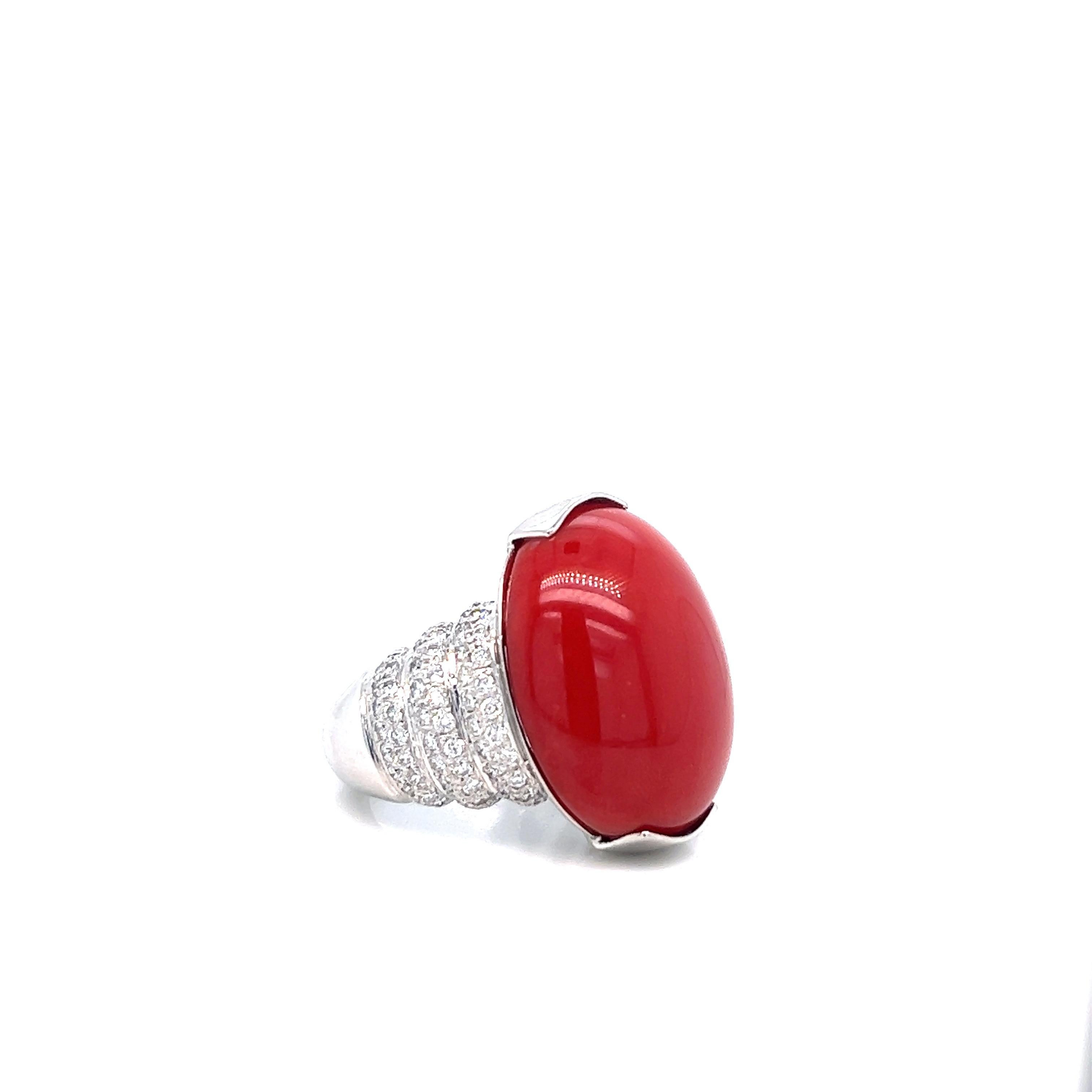 A classic cocktail ring featuring a cabochon ox blood-colored coral at its center. Surrounding the coral are round diamonds weighing approximately 1.5 carat. Coral's measurements: 23.8 mm x 19.3 mm. Marked: Pt 900 / D 1.50. Total weight: 28.5 grams.