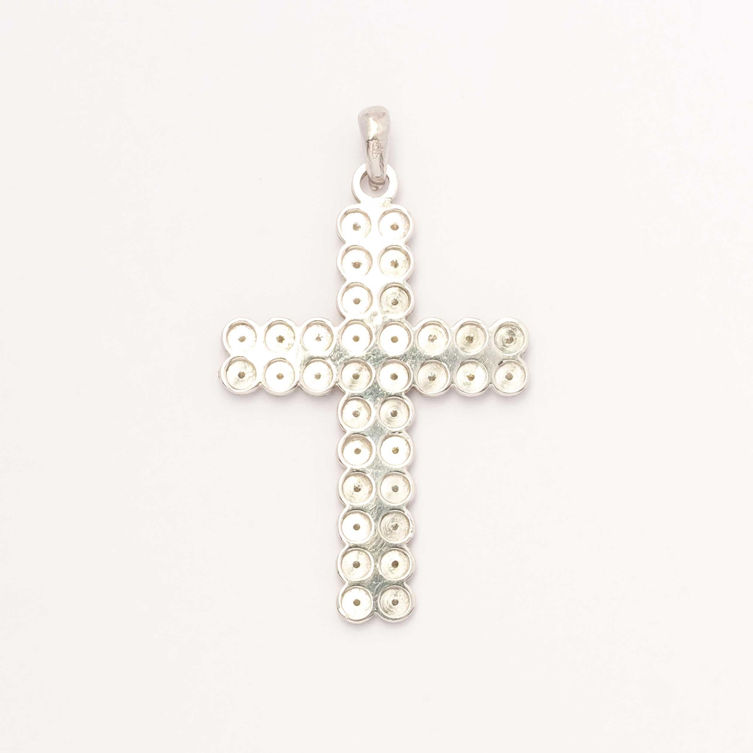 Pendentif raffiné en forme de croix réalis�é en platine, poinçonné 950 Vicenza. Un bijou d'une élégance discrète, serti de diamants taille brillant d'un poids total d'environ 0,68 ct. Une pièce vintage alliant spiritualité et artisanat