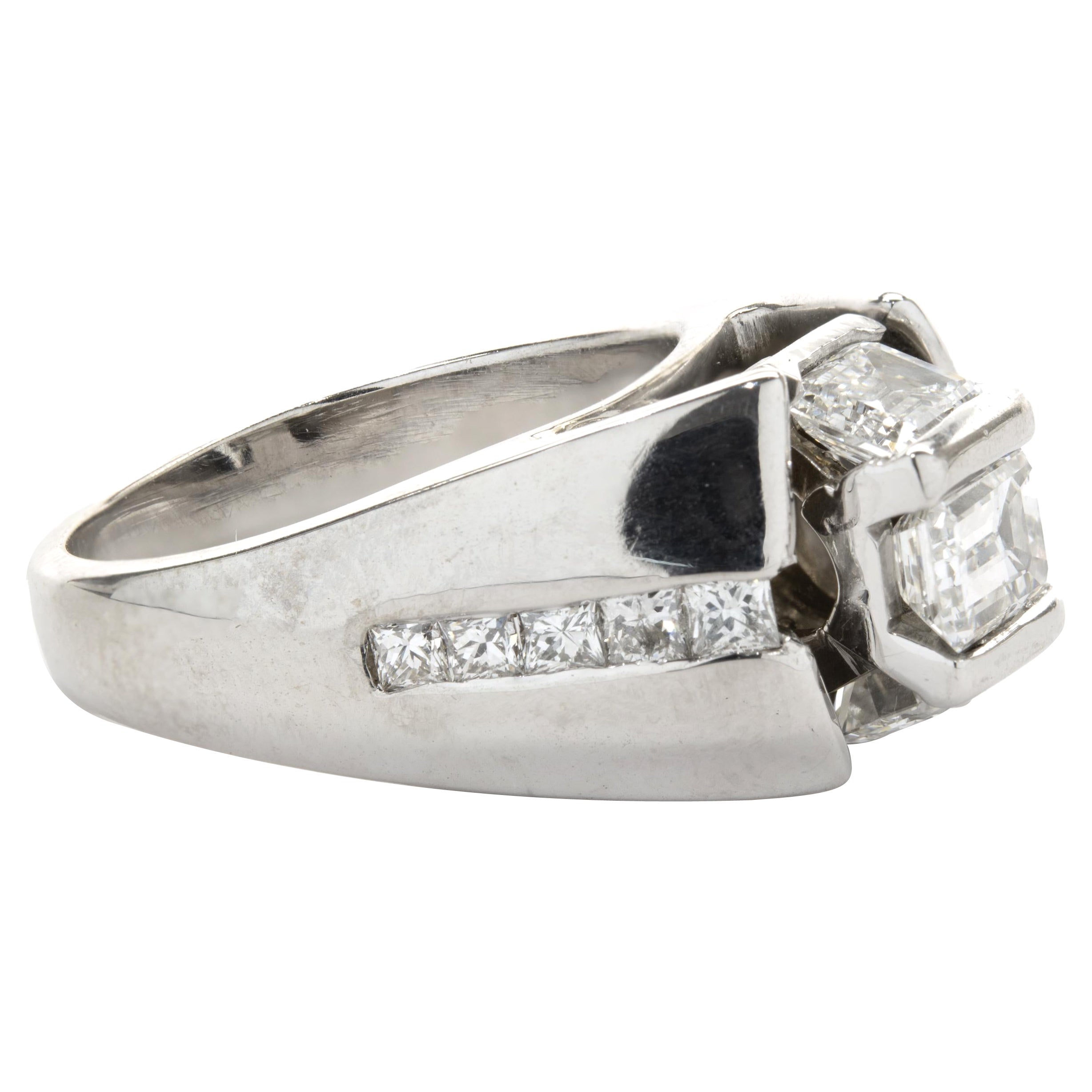 Designer: personalizzato
Materiale: platino
Diamante: 1 taglio smeraldo = .64ct
Colore: H
Chiarezza: SI1
Diamanti: 10 princess, 8 tondi taglio brillante, 2 smeraldo = 1,02cttw
Colore: G. H.
Chiarezza: VS2-SI1
Misura dell'anello: 7 (si prega di