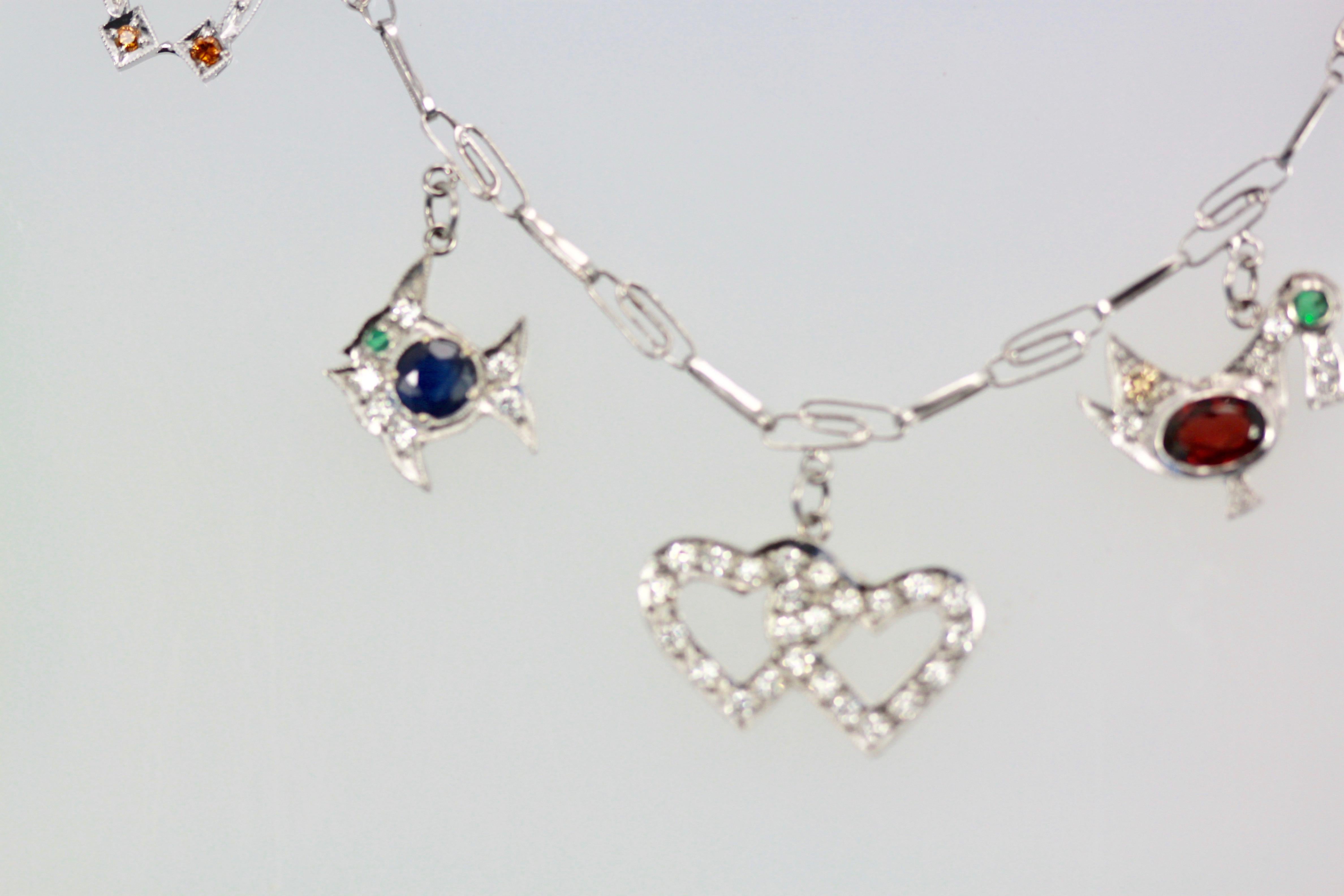 Gorgeous Deco Charm Necklace holds 7 unique charms, they are Palm Tree, Umbrella, Fish, Double Heart, Horseshoe, bird and seagull.  These are all complete  with Diamonds and other gemstones such as, Topaz, Garnet, Ruby, Emerald, and Sapphire. This