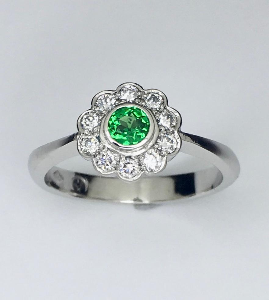Platinum Demantoid Diamond Cluster Ring

Daisy cluster ring contains round dementoid garnet in bezel setting at the center. There is 10 round brilliant cut diamond surrounding the center stone forming a scallop cluster head. Band stamped 950, round
