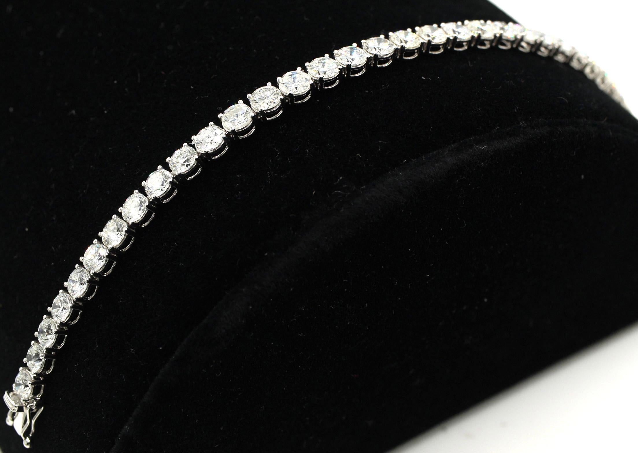 Esta pulsera tenis de platino magistralmente elaborada a mano está engastada con 38 diamantes redondos de talla brillante perfectamente combinados con un peso total de 12,84  quilates - que está estampado en el cierre de la pulsera Esta pieza de