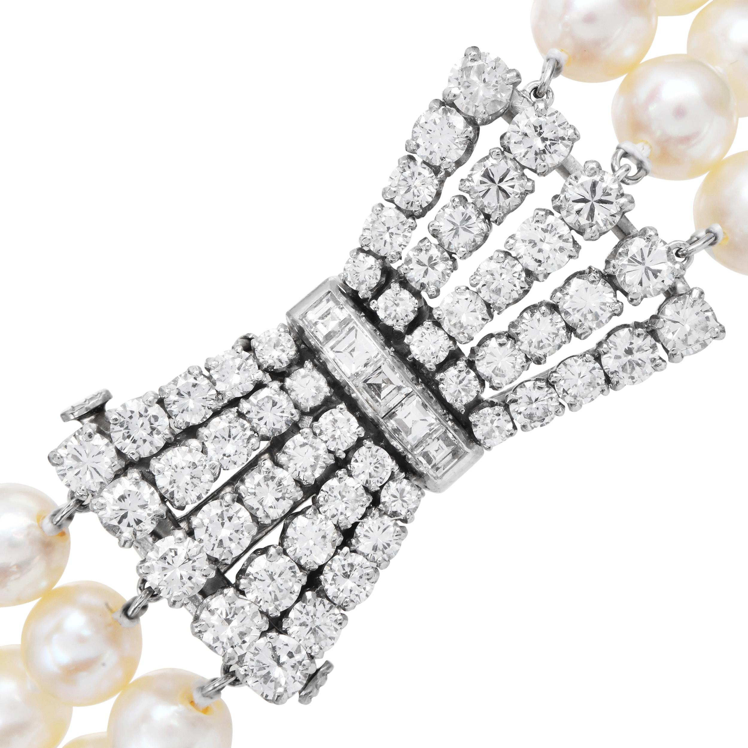 A refined three-strand pearl bracelet designed with a platinum diamond bow clasp. The bracelet features 6 mm cream white cultured pearls arranged in smooth, uniform rows. The center clasp is set with round brilliant and carré cut diamonds that form