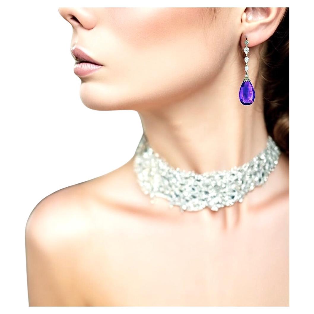 Platinum pendant style earrings possessing both round and pear cut diamonds by Pierre/Famille.   These collet set stones weigh 3.83 cts. They are estimated to be near colorless and very slightly included, H,VS.  The vivid purple amethysts with a