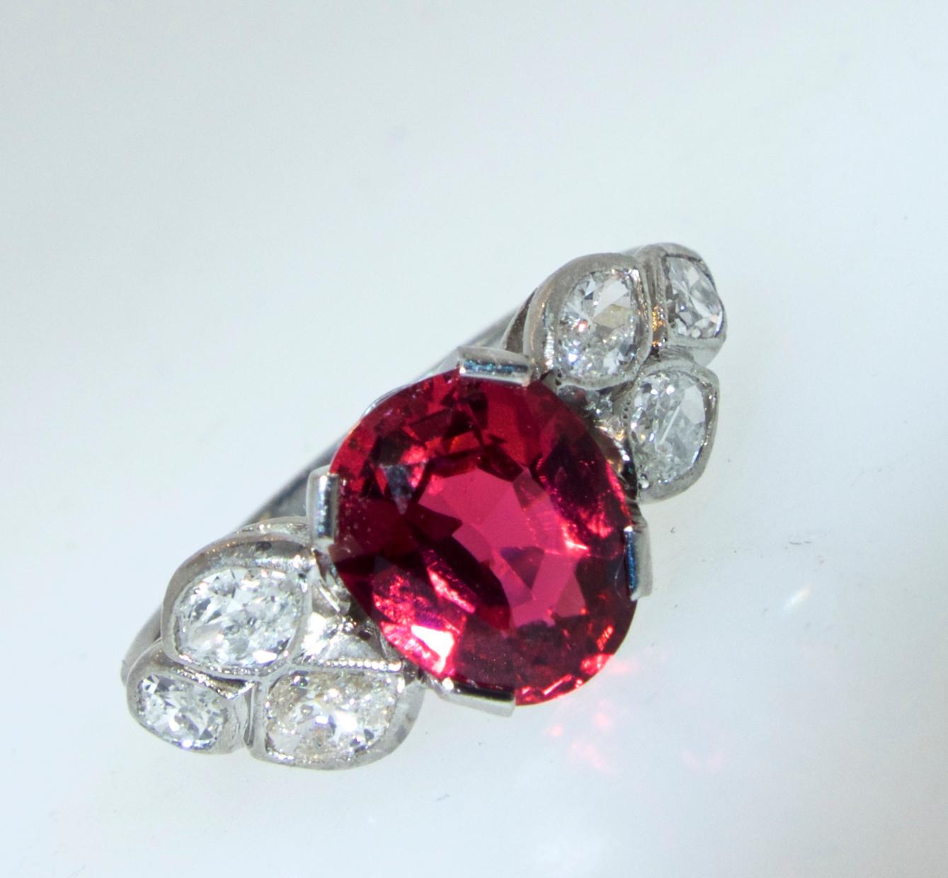 The center natural spinel is clear, bright and a vivid red color.  It weighs 2.04 cts.  Accenting this center stone are fine white diamonds.  The 6 marquis cut diamonds are all well matched, well cut and white.  They are approximately very slightly