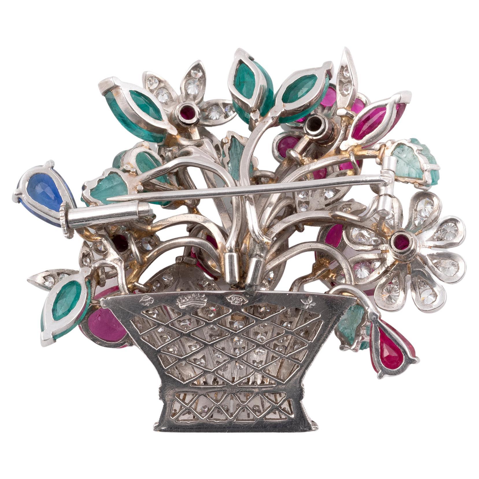 
In Form eines Blumenkorbs, besetzt mit geschnitzten Rubinen, Saphiren und Smaragden im Rundschliff und Cabochon, mit Diamanten im Brillantschliff, Diamanten insgesamt ca. 1,30cts, Länge 4,3cm