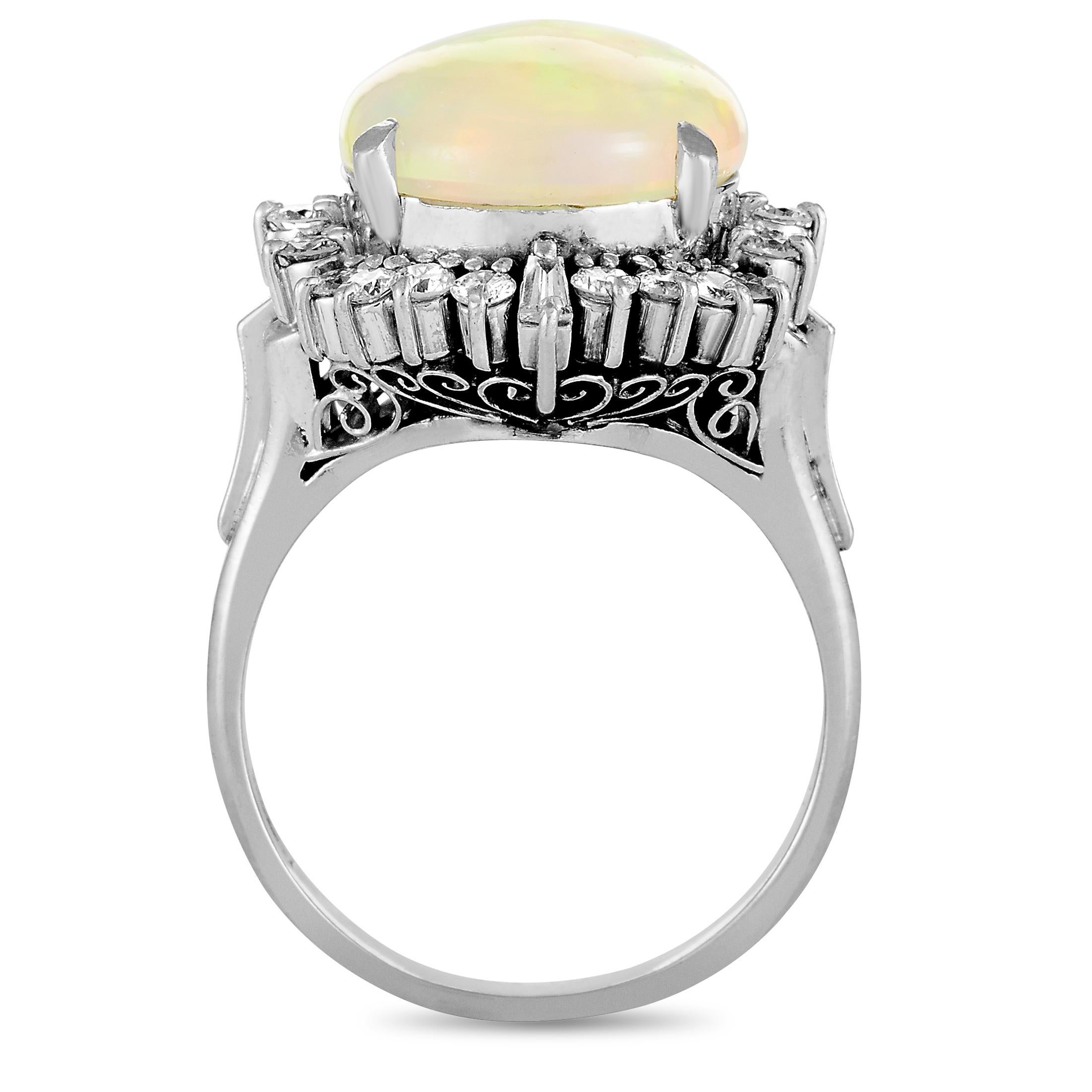 This ring is made of platinum and weighs 8.8 grams. It boasts band thickness of 2 mm and top height of 10 mm, while top dimensions measure 15 by 19 mm. The ring is set with an opal that weighs 4.54 carats and with diamonds that total 0.60