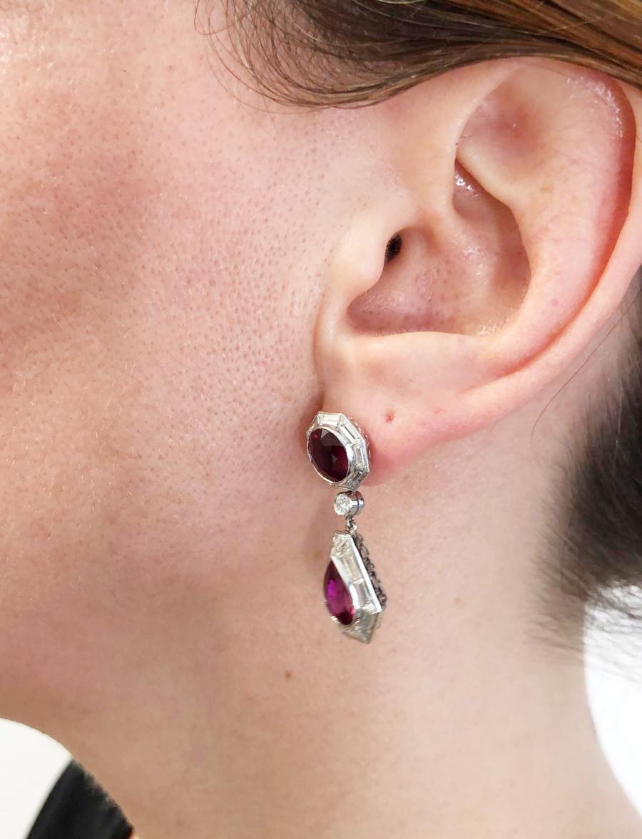 Contemporary Ruby Diamond Drop Earrings in Platinum.

A classic pair of earrings featuring round faceted rubies with dropped pear-shaped rubies, surrounded with halos of step-cut white diamonds. The depth of crimson in the rubies is starkly