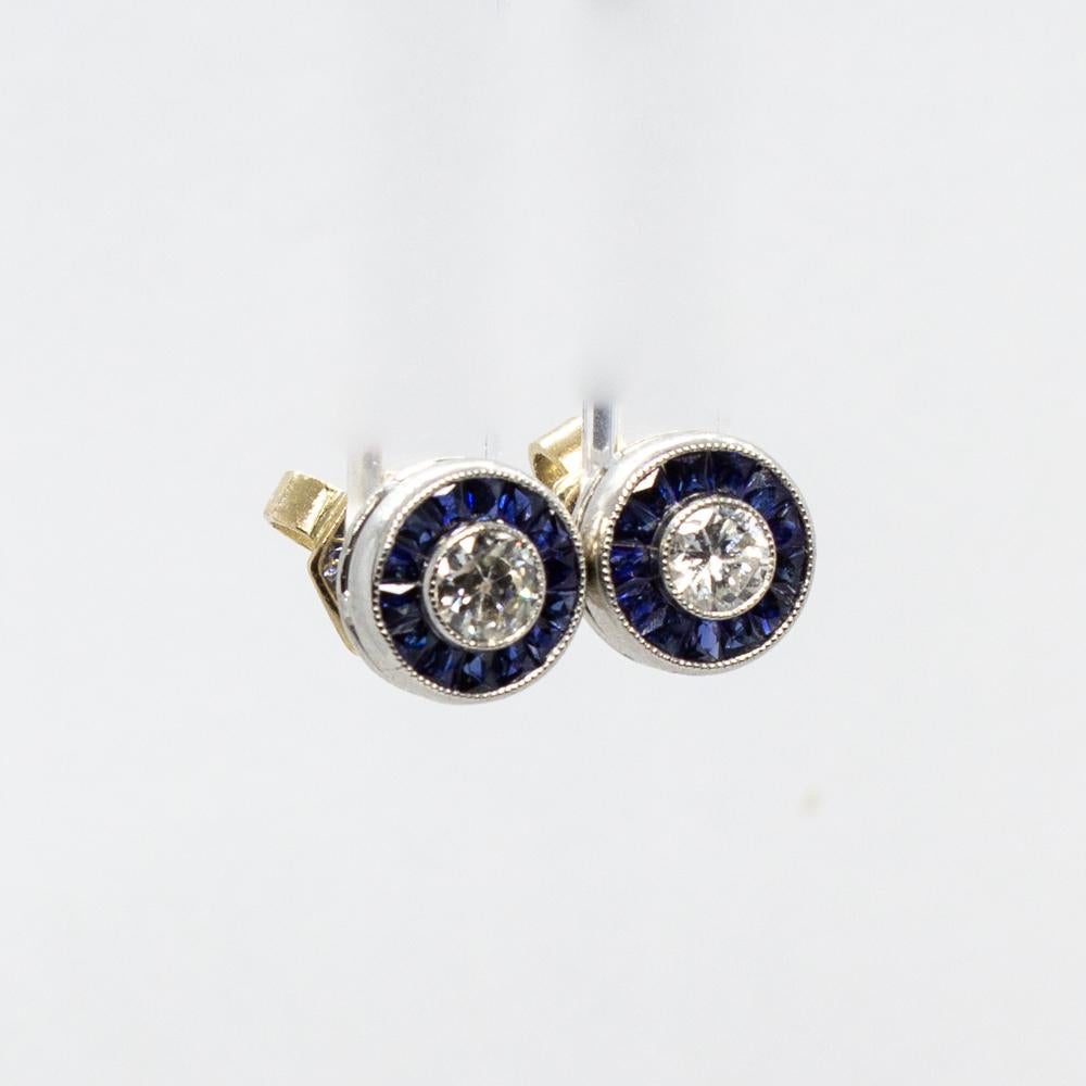 Composition: Platinum
Stones:
•	2 Old mine cut diamonds of H-VS2/SI1 quality that weigh 0.60ctw. 
•	24 natural French cut sapphires that weigh 0.90ctw.
Earring measures: 9mm in diameter. 
Thick: 4mm
Total weight: 3.6grams – 2.3dwt 
This is an