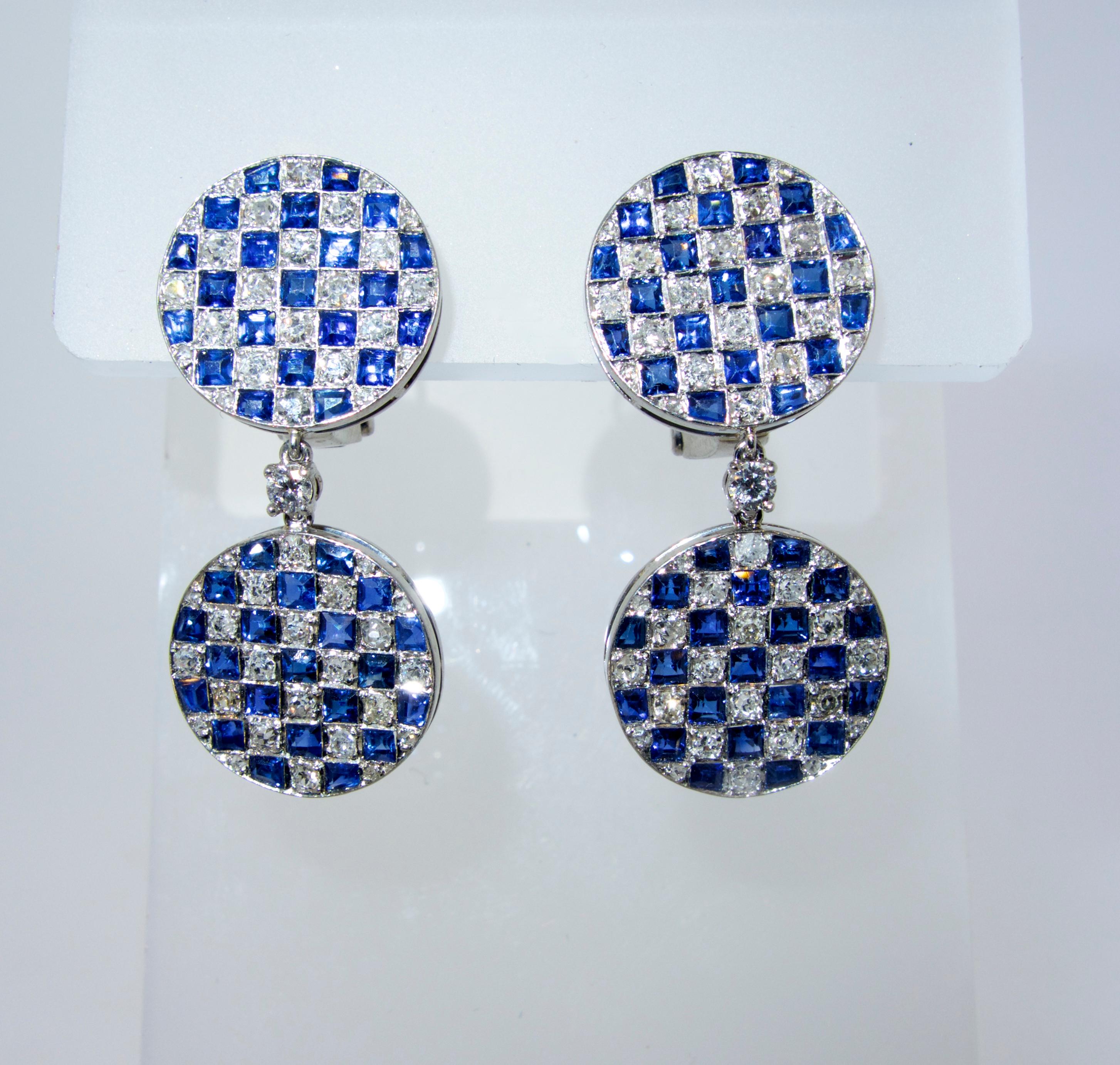 Sapphire, diamond and platinum checkerboard motif earrings, pendant style, which are 1.25 inches long and possessing fine white diamonds and bright blue natural square cut sapphire.  There are 94 round white diamonds weighing approximately 2.65