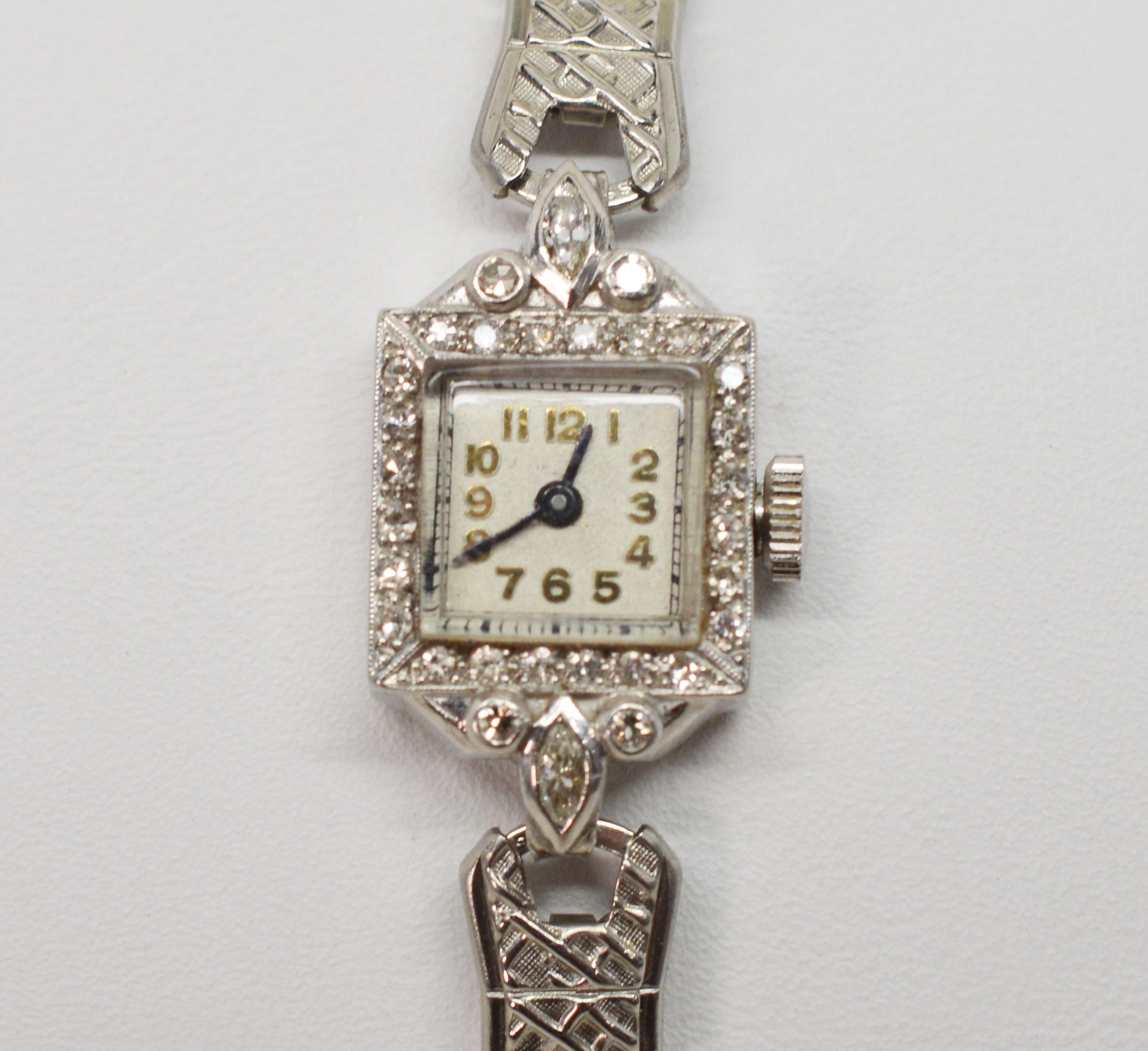 Platinum and Diamond Antique Ladies Wrist Watch with new steel stretch band. Watch face is framed with twenty eight H/I1 diamonds with a total weight of one third carat. The new replacement band with complementary matte finish stretches in a range