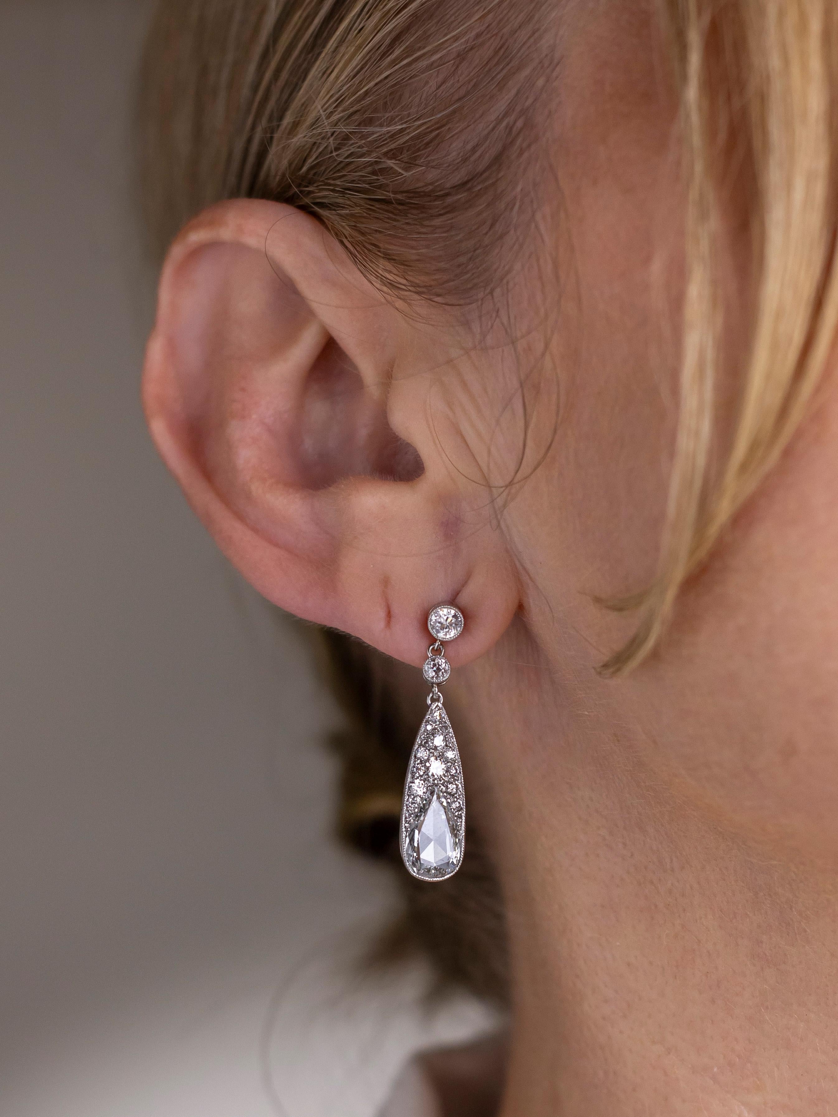 Hand crafted from platinum and set with diamonds this pair of earrings are in the Belle Epoque taste whilst being of relatively modern manufacture. The drop earrings have been manufactured with a mixture of different diamond cuts including old