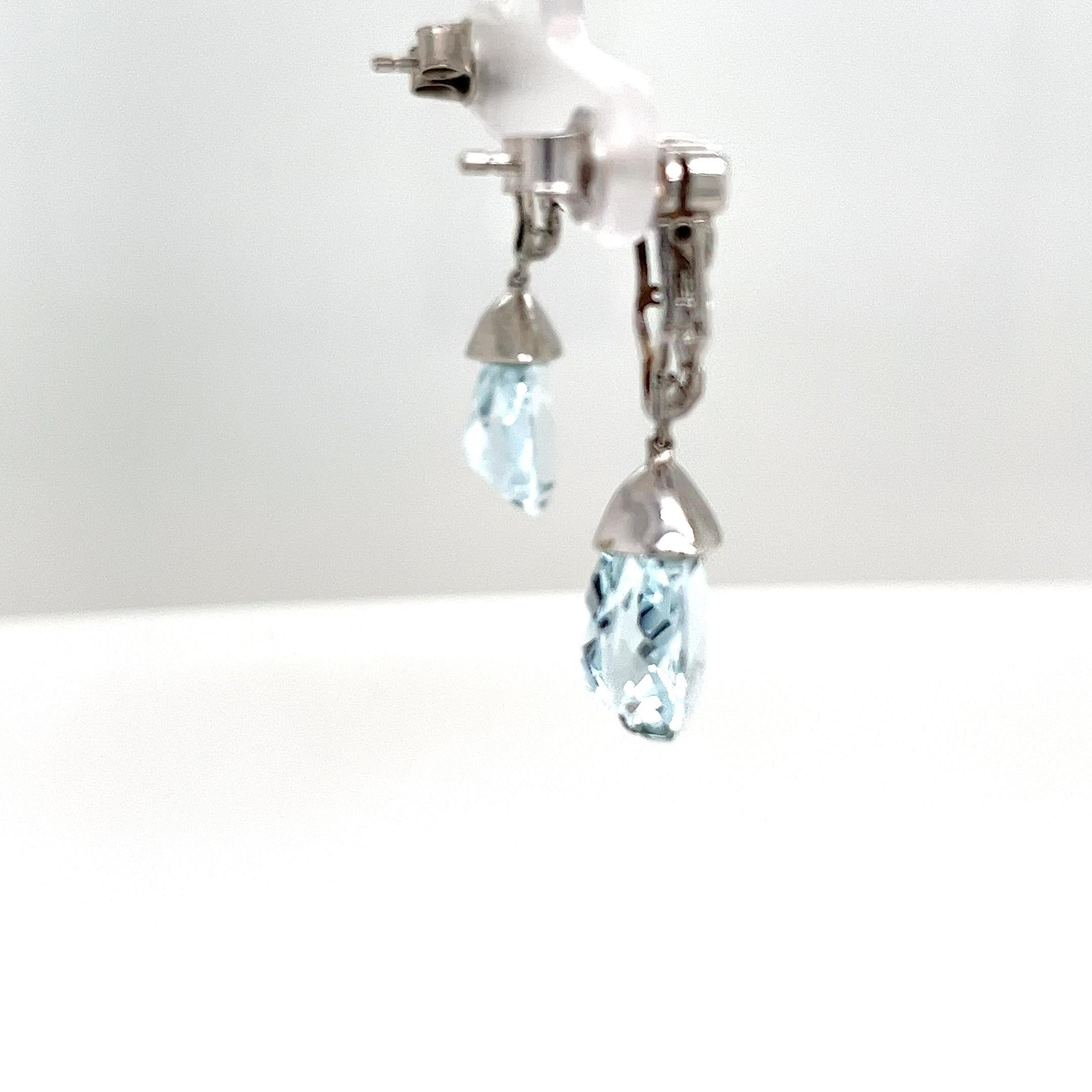 Uno splendido paio di orecchini in platino, con gemme naturali di topazio blu splendidamente disposte in un design classico e impreziosite da brillanti. La forma elegante simboleggia la raffinatezza, 
che rende questi orecchini un'aggiunta perfetta