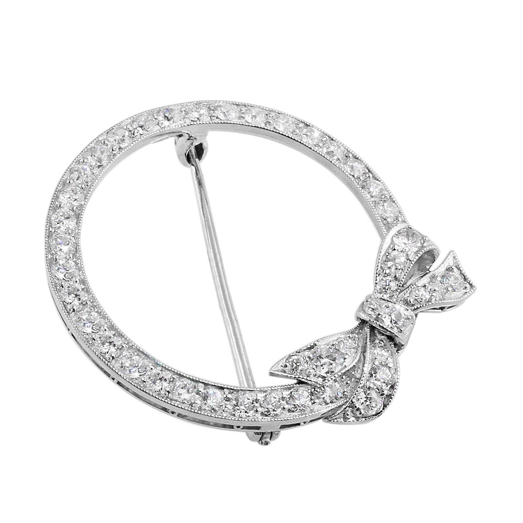 Estate Diamond Bow Round Brooch. Platinum round brooch with a bow, set with 44 diamonds weighing approximately 1.76cttw.