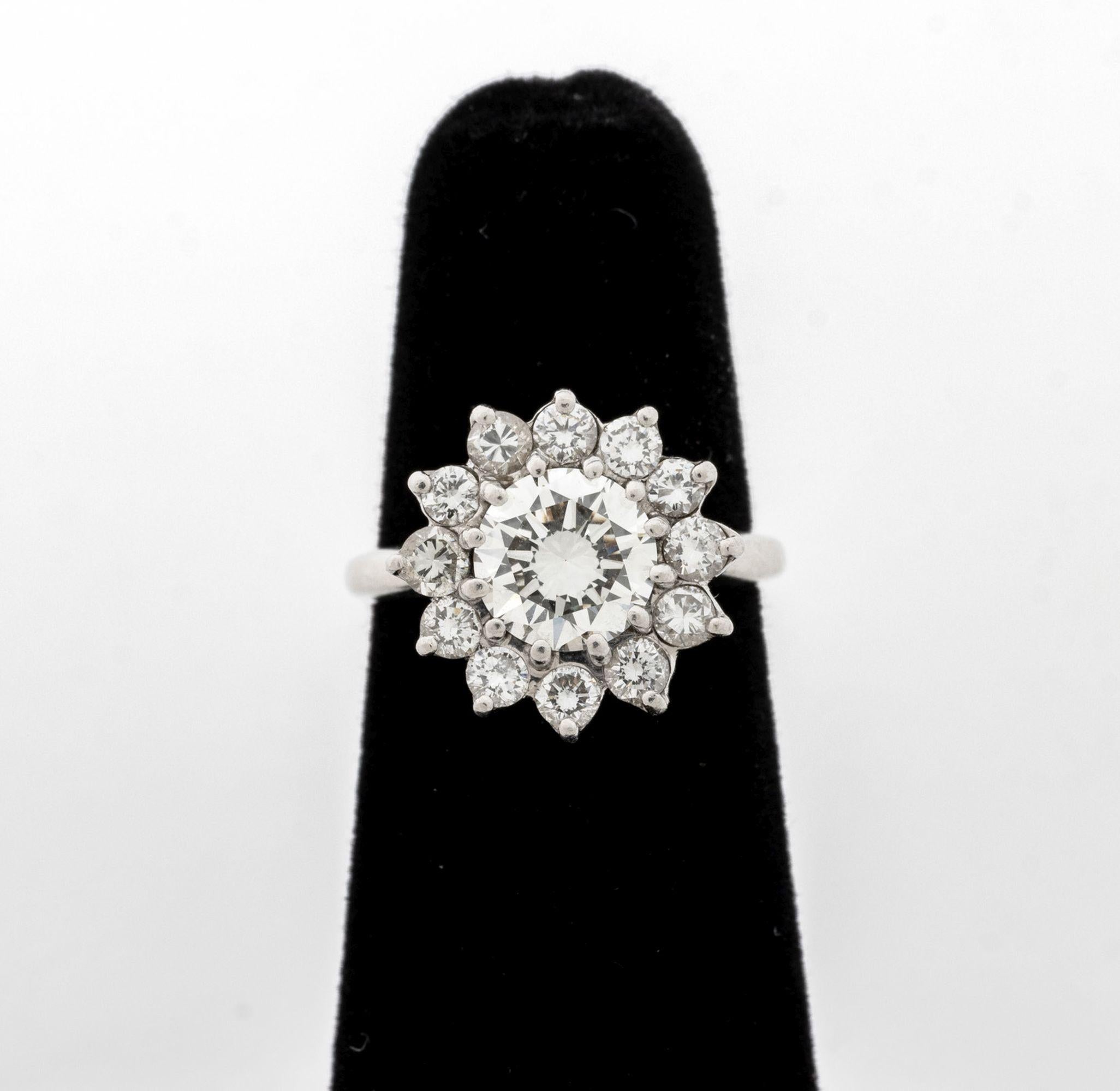 Anello a grappolo di diamanti in platino, con un diamante rotondo taglio brillante incastonato al centro, del peso di circa 1,15 carati, colore H-I / purezza VS2, circondato da dodici diamanti rotondi taglio brillante incastonati, del peso totale di